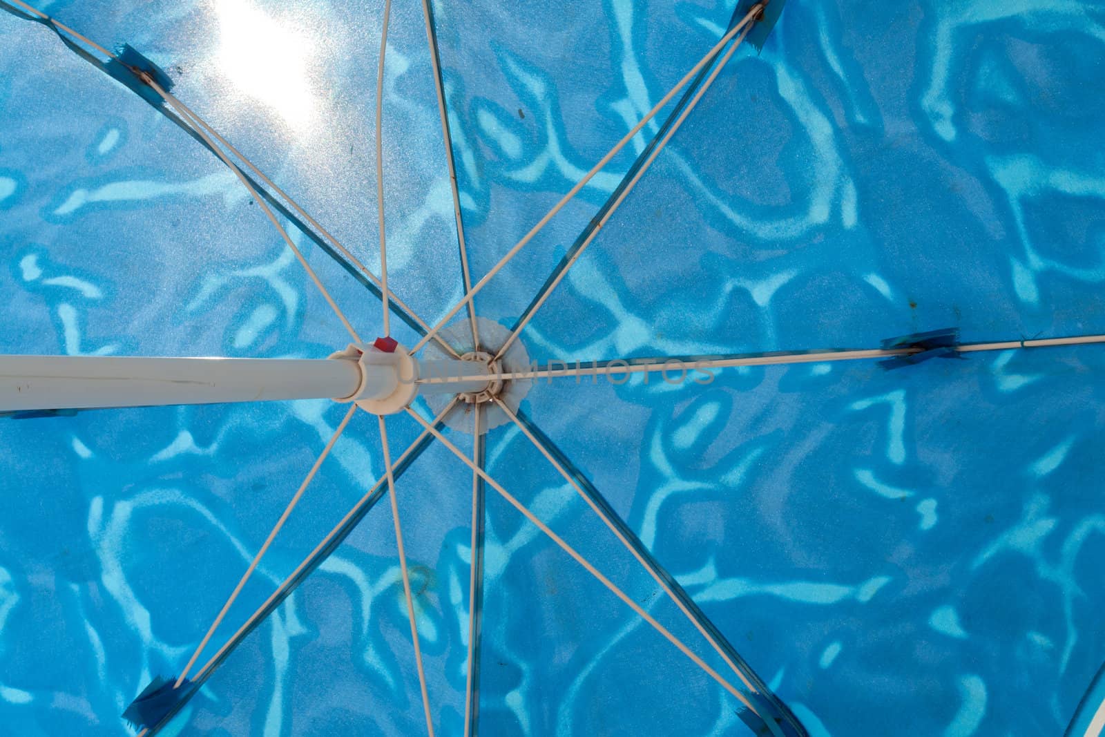 Beach umbrella parasol against sunny clear blue summer sky 