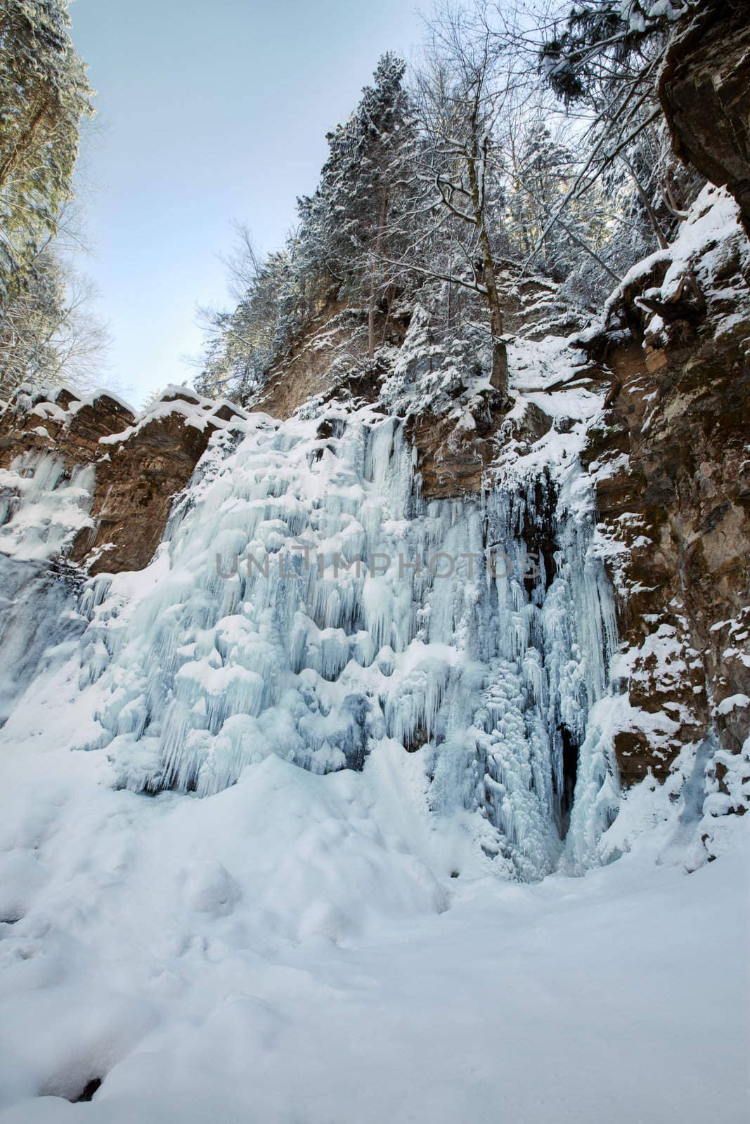 Image of a frozen waterfall in deep rock canyon in Carpathian mountains near Manyava village