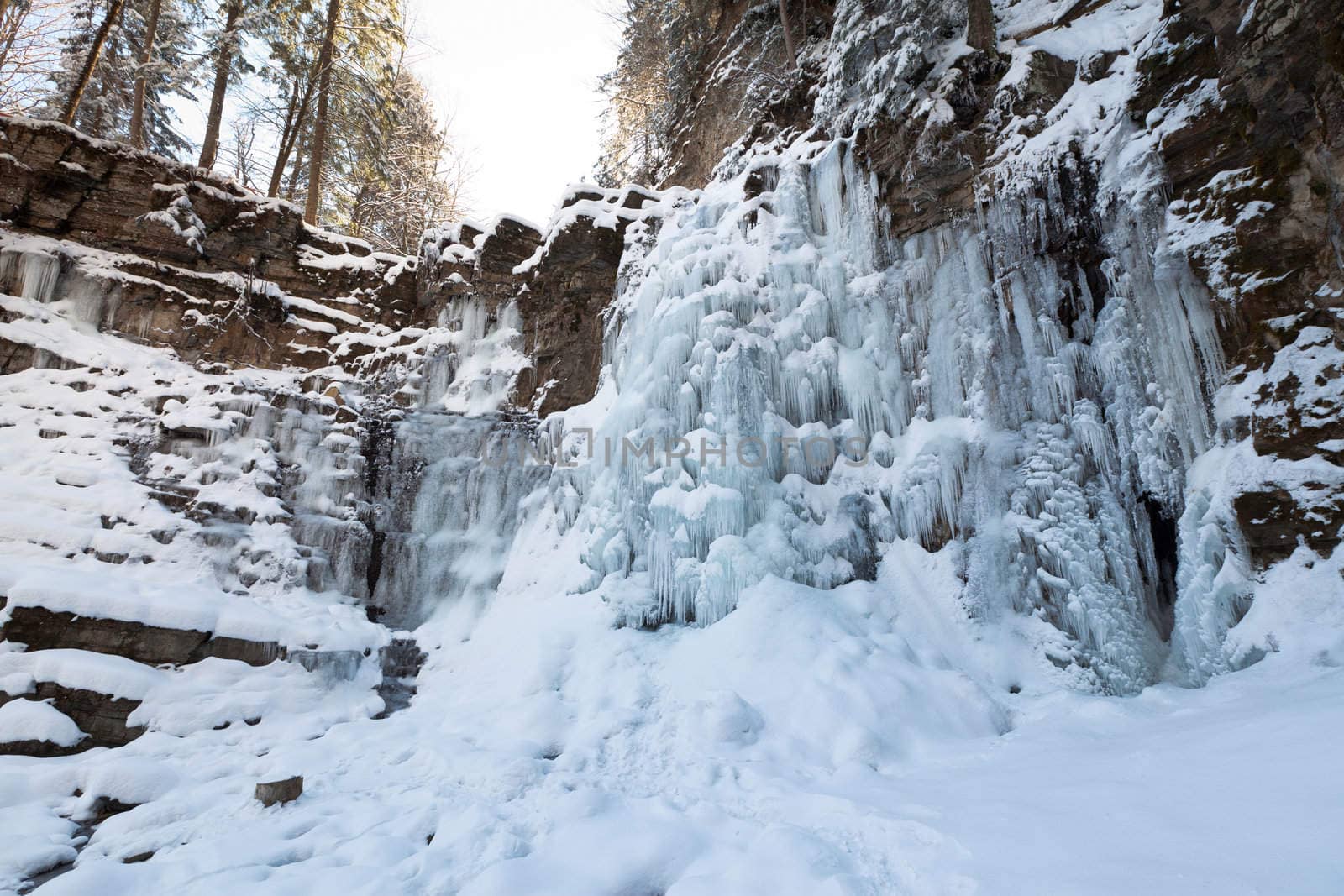 Image of a frozen waterfall in deep rock canyon in Carpathian mountains near Manyava village