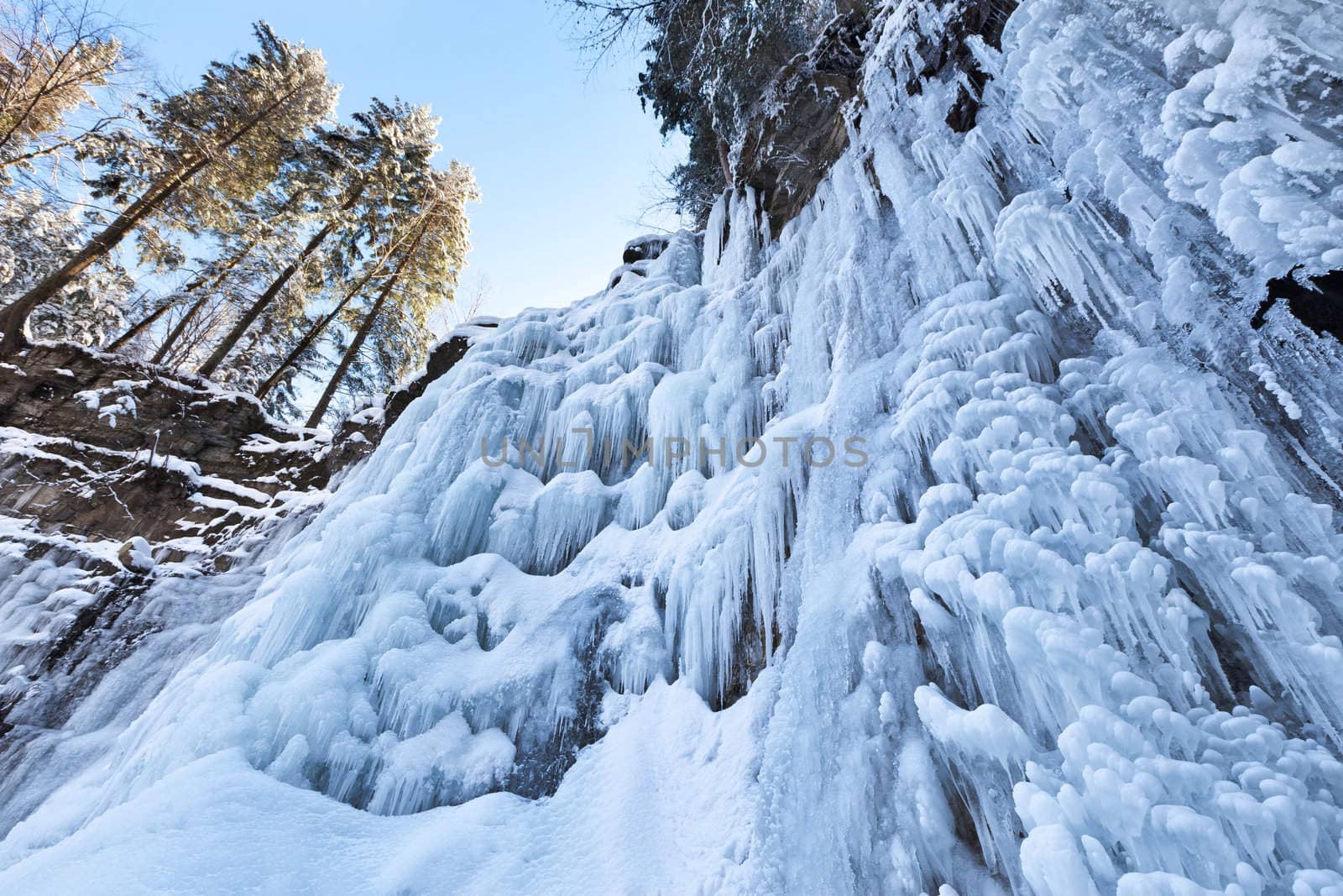 Image of a frozen waterfall in deep rock canyon in Carpathian mountains near Manyava village