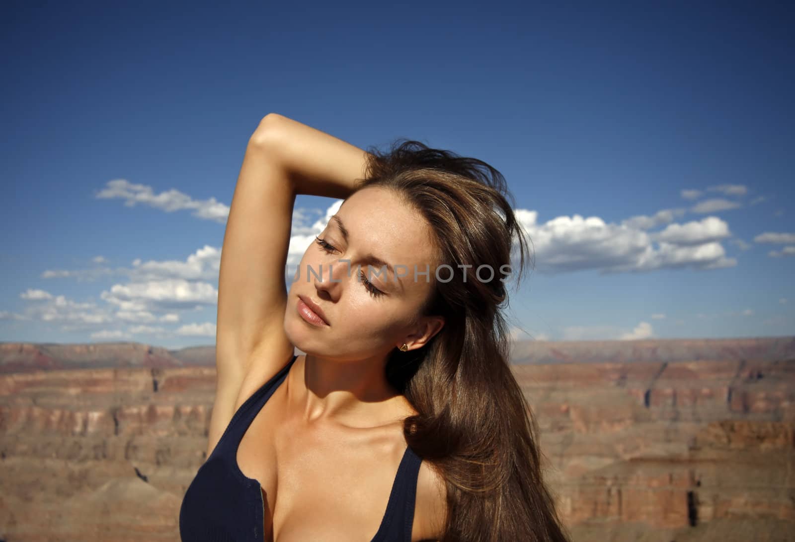 Beautiful brunette on a background of the dark blue sky in Grand Canyon