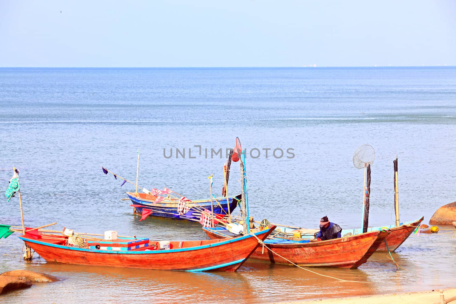 fisherman cleaning his boat on the beach