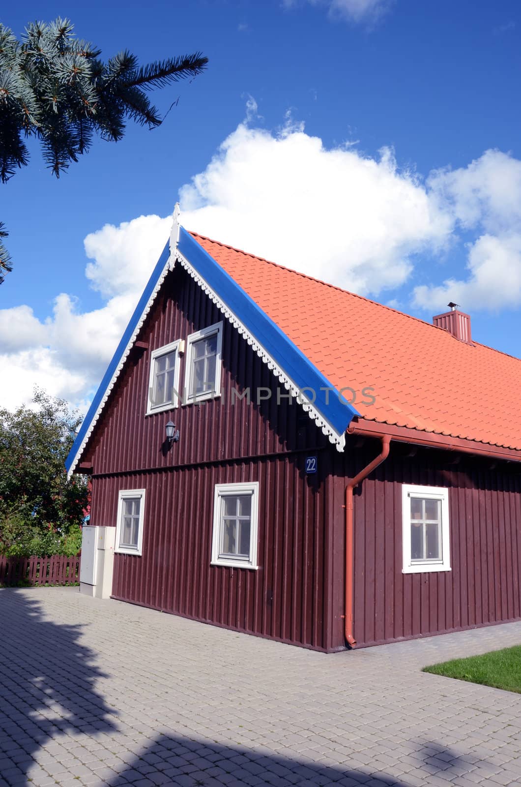 Colorful house details. Brown house with red tailed roof.