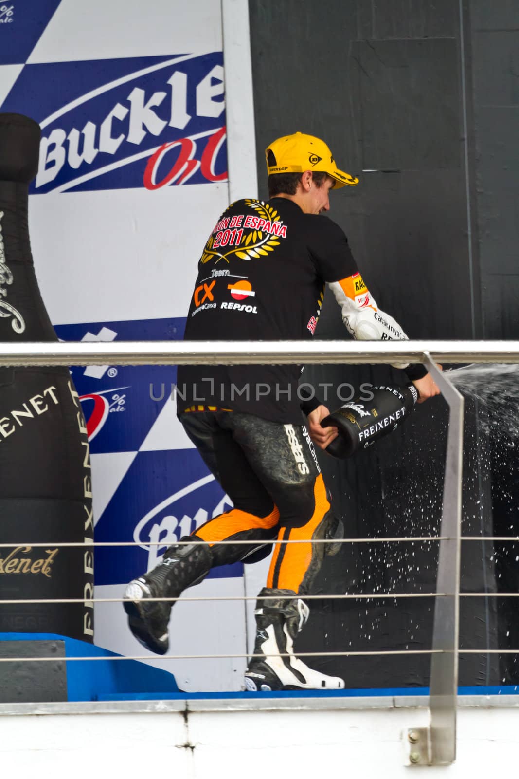 JEREZ DE LA FRONTERA, SPAIN-NOV 20: 125cc motorcyclist Alex Rins on the podium like winner of the 125cc CEV Championship celebrating with champagne on November 20, 2011, in Jerez de la Frontera, Spain