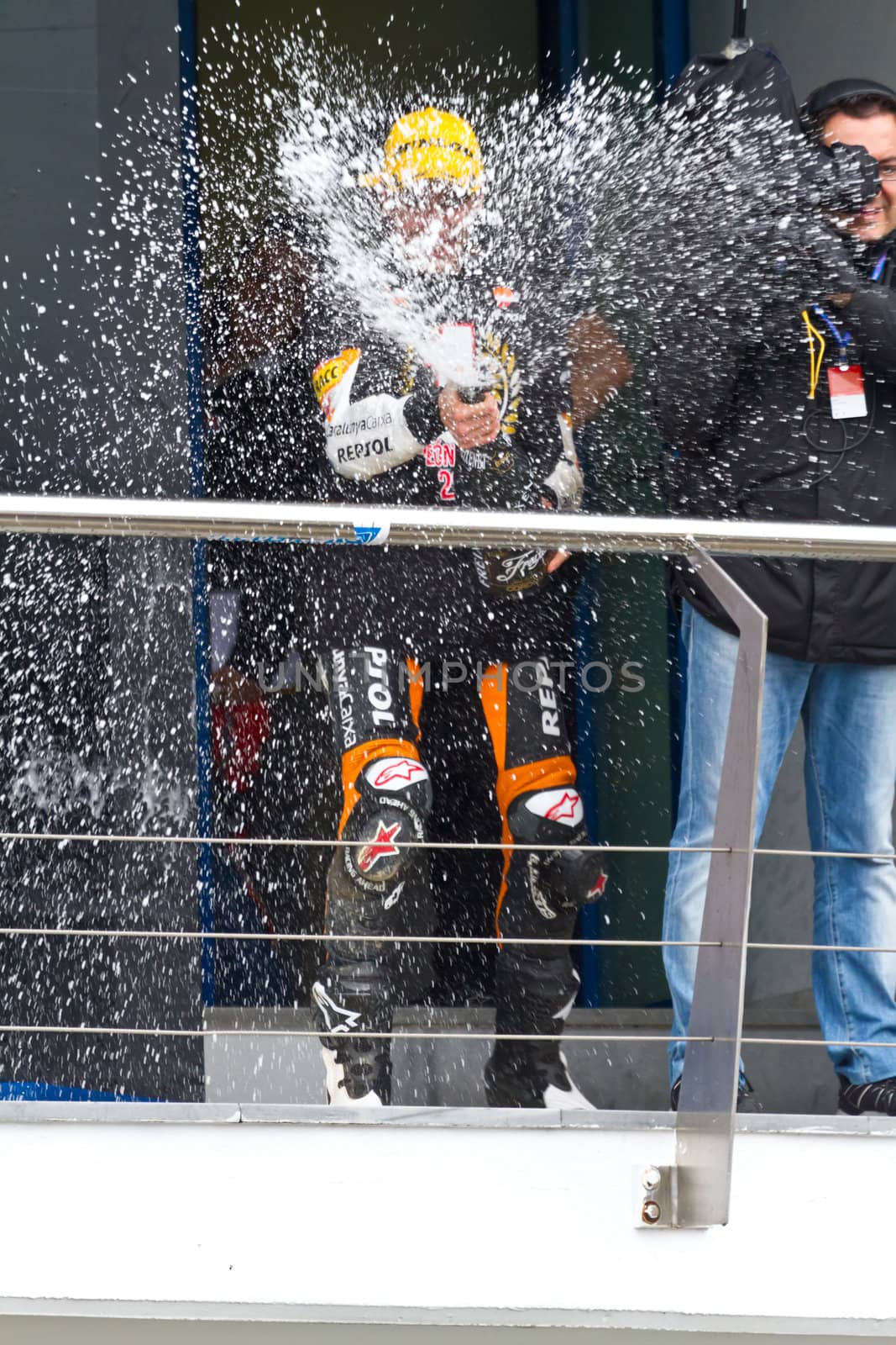 JEREZ DE LA FRONTERA, SPAIN-NOV 20: 125cc motorcyclist Alex Rins on the podium like winner of the 125cc CEV Championship celebrating with champagne on November 20, 2011, in Jerez de la Frontera, Spain