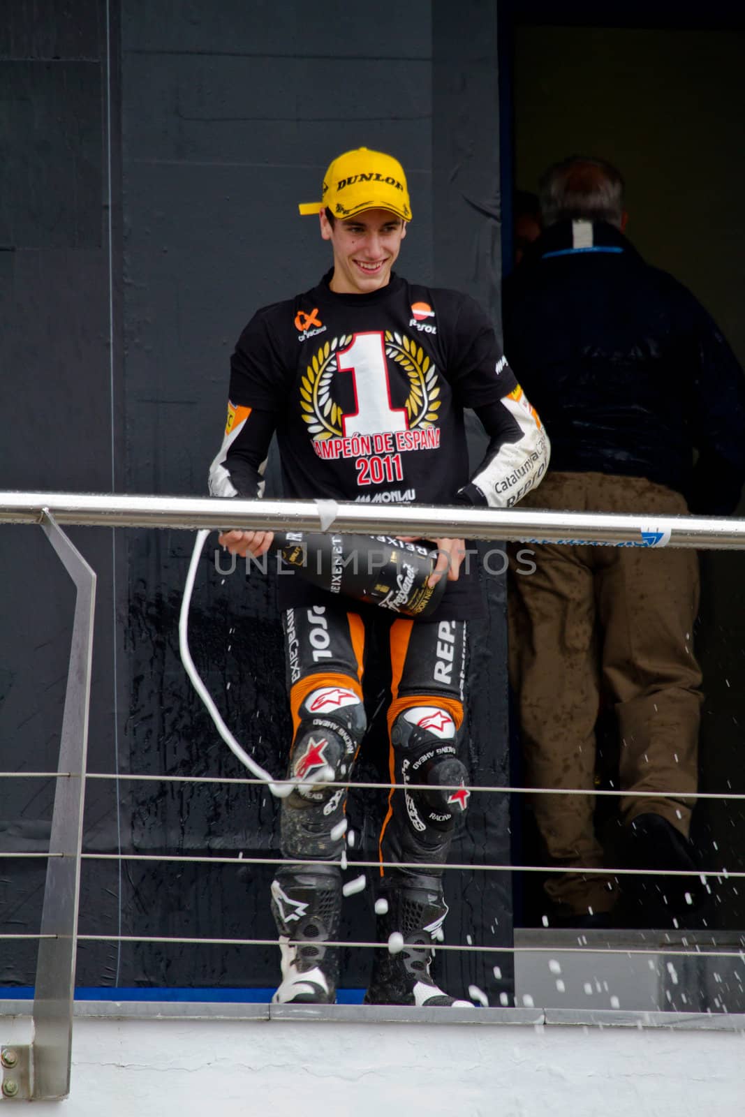JEREZ DE LA FRONTERA, SPAIN-NOV 20: 125cc motorcyclist Alex Rins on the podium like winner of the 125cc CEV Championship celebrating with champagne on November 20, 2011, in Jerez de la Frontera, Spain