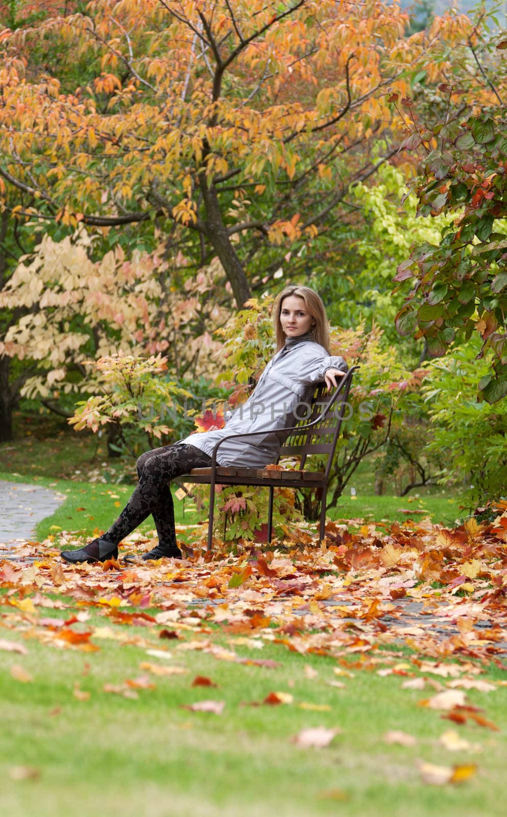 Girl on small bench in autumn park