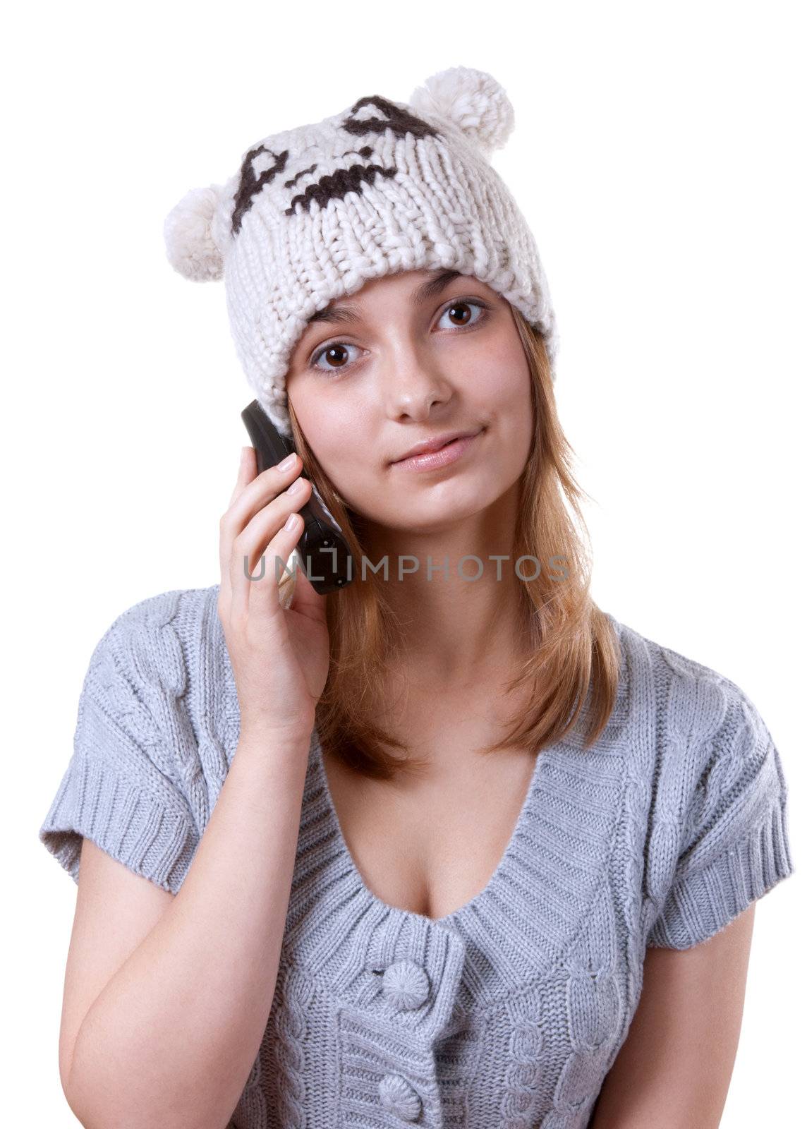 Beautiful girl in winter hat with telephone on white background