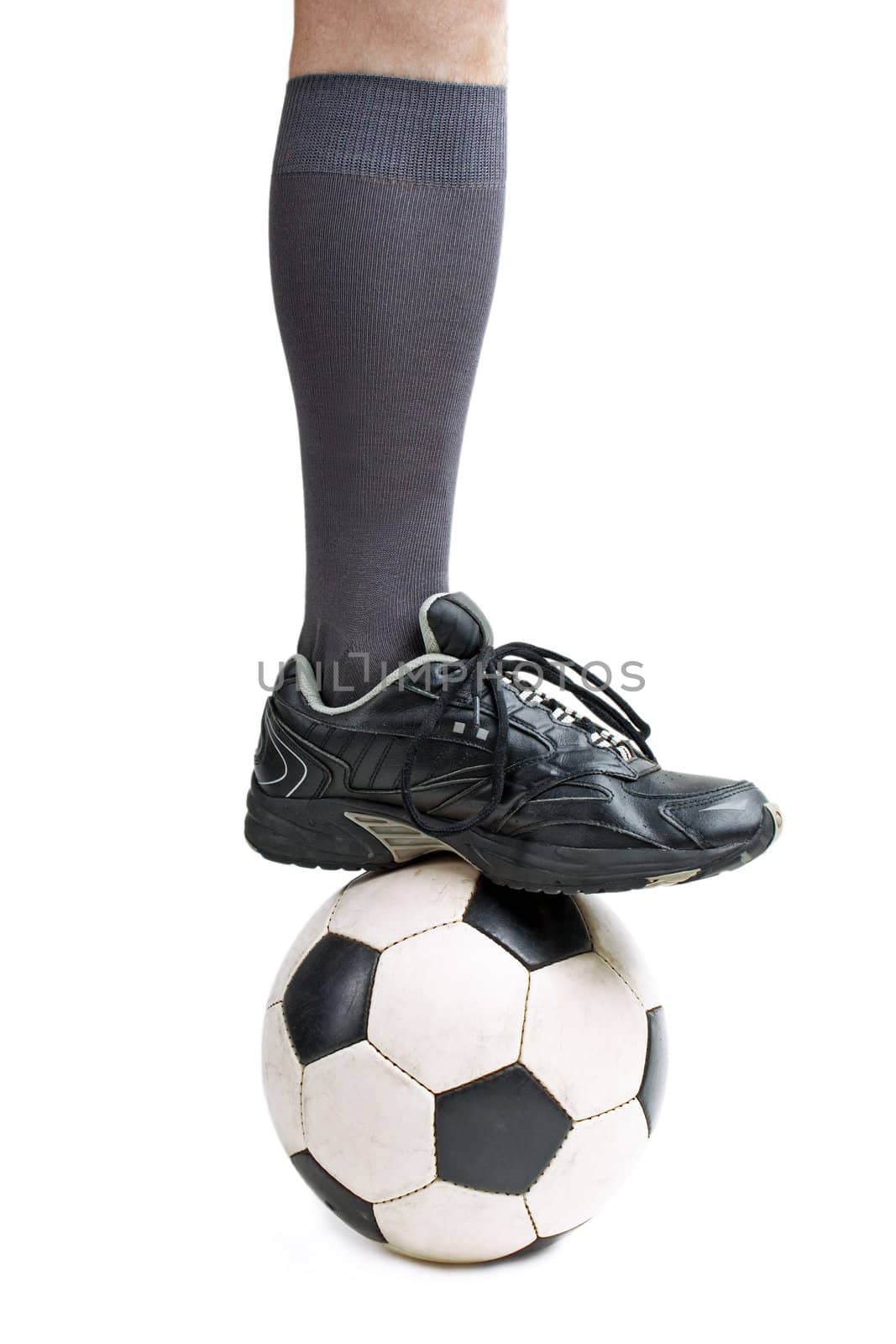 Foot on black white football or soccer sport ball