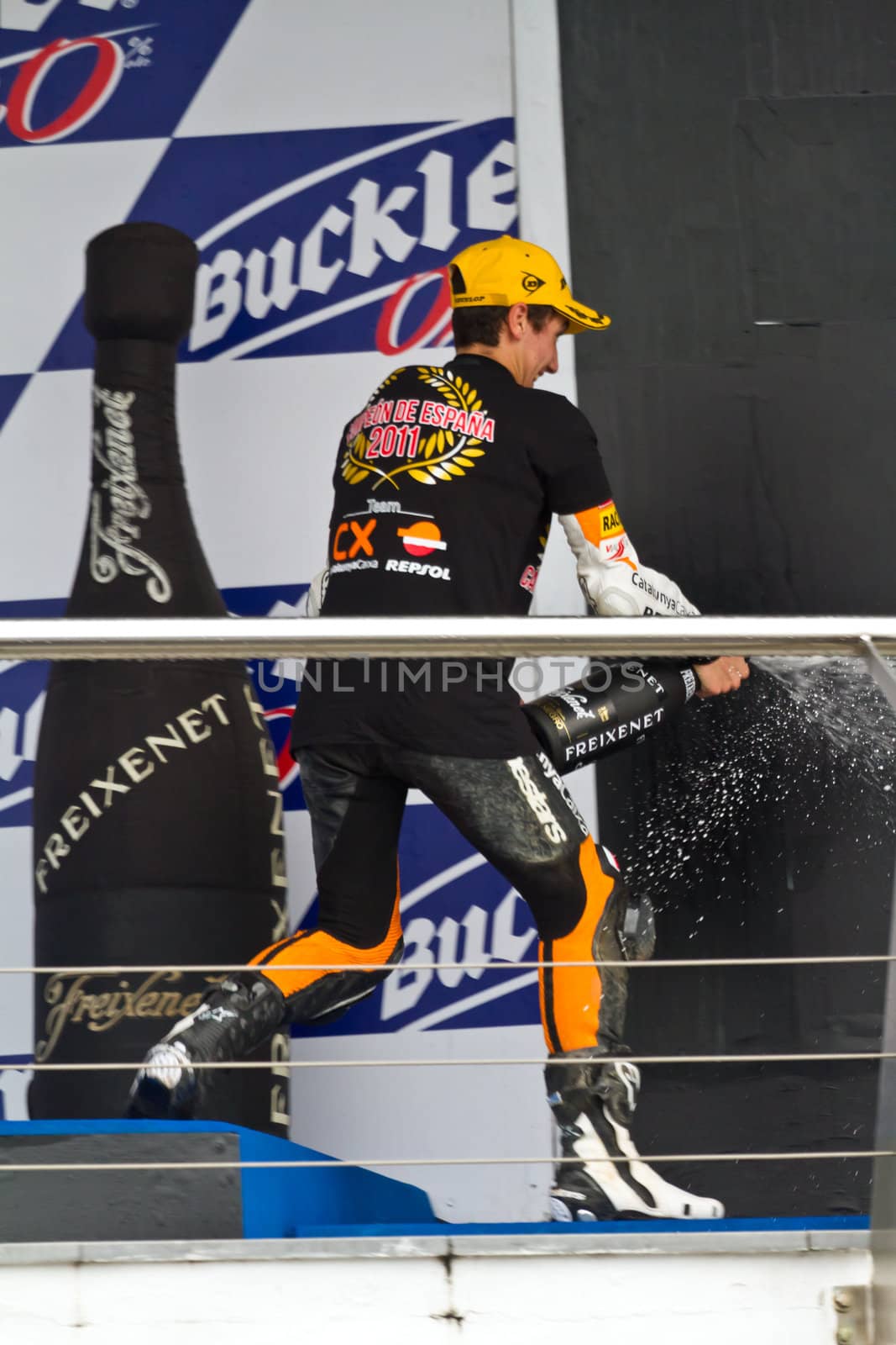 JEREZ DE LA FRONTERA, SPAIN-NOV 20: 125cc motorcyclist Alex Rins on the podium like winner of the 125cc CEV Championship celebrating with champagne on November 20, 2011, in Jerez de la Frontera, Spain