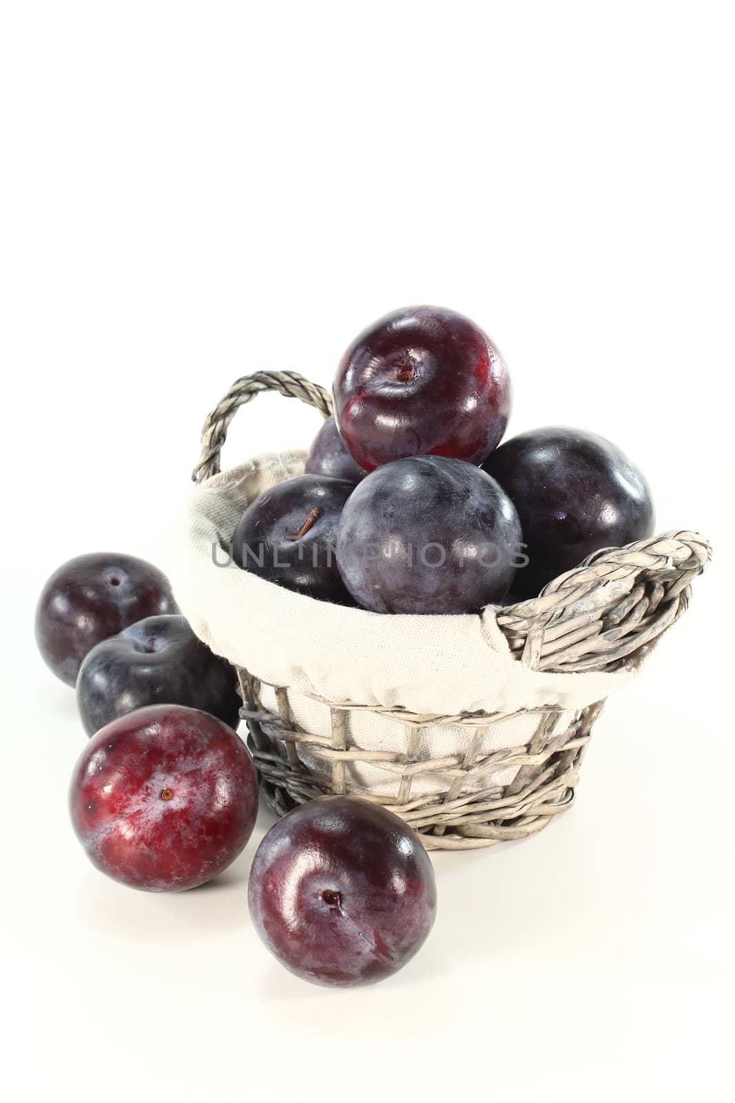 Fresh plums with leaves in a basket