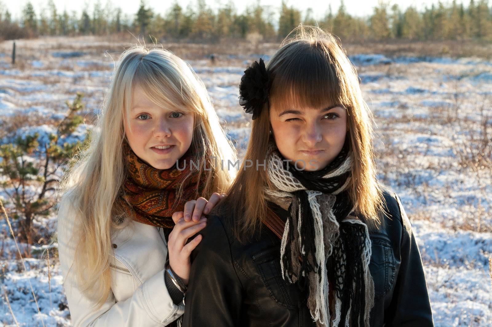 Two young beautiful girls on snow landscape