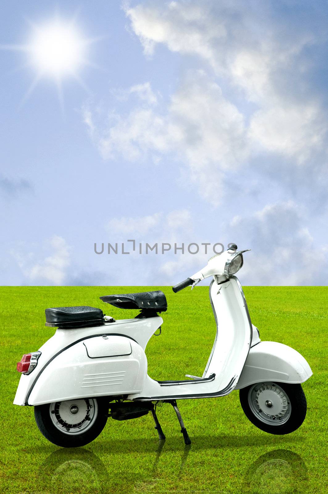 White retro vespa on grass in the garden with sky