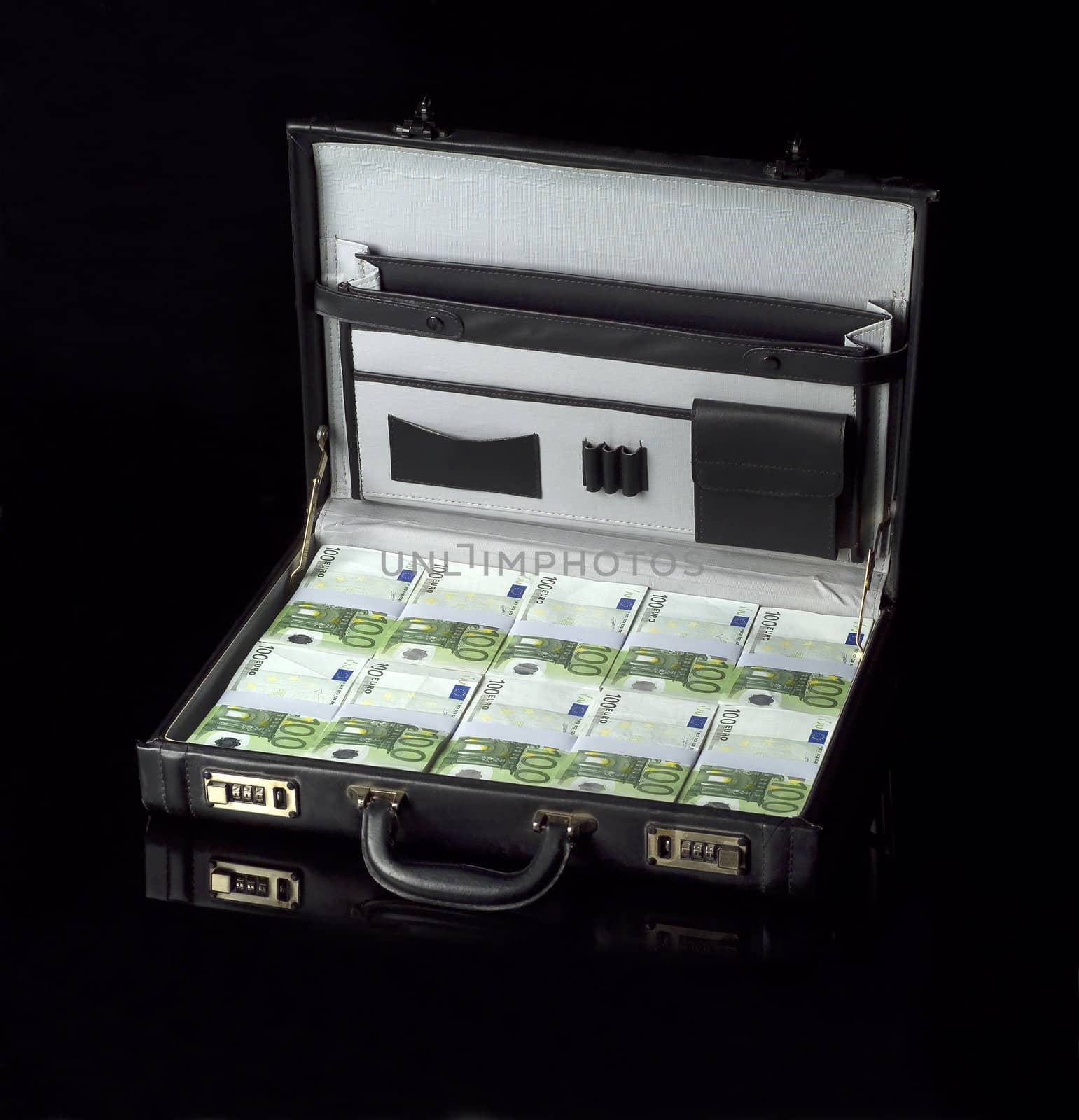 Briefcase with money isolated on black background