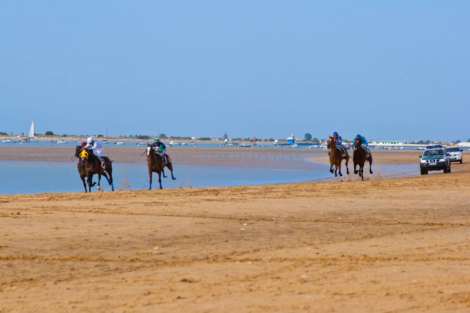 SANLUCAR DE BARRAMEDA, CADIZ, SPAIN - AUGUST 11: Unidentified riders race horses on Sanlucar de Barrameda beach on August 11, 2011 in Sanlucar de Barrameda, Cadiz, Spain.