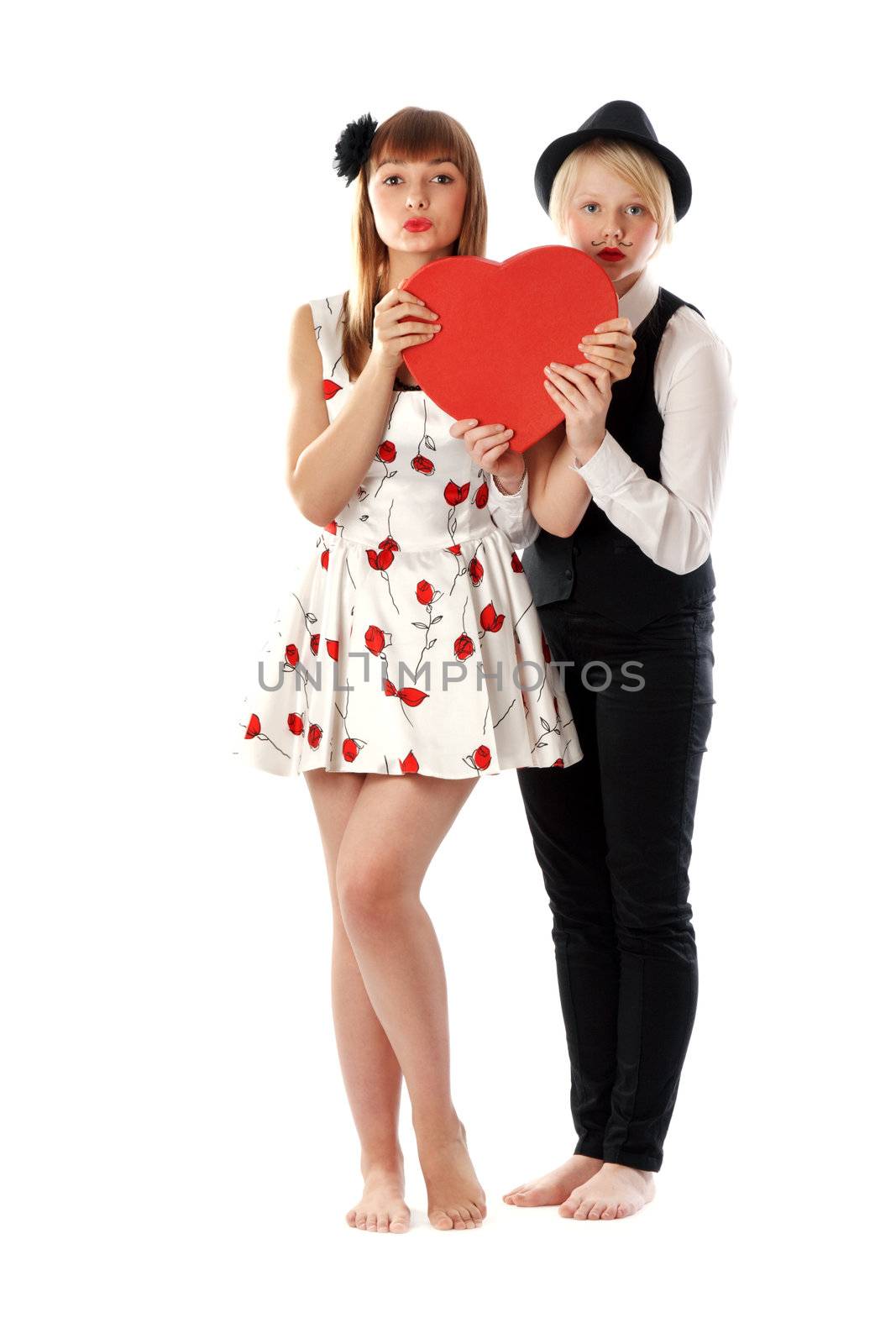 Two girls with red cardboard heart on white background