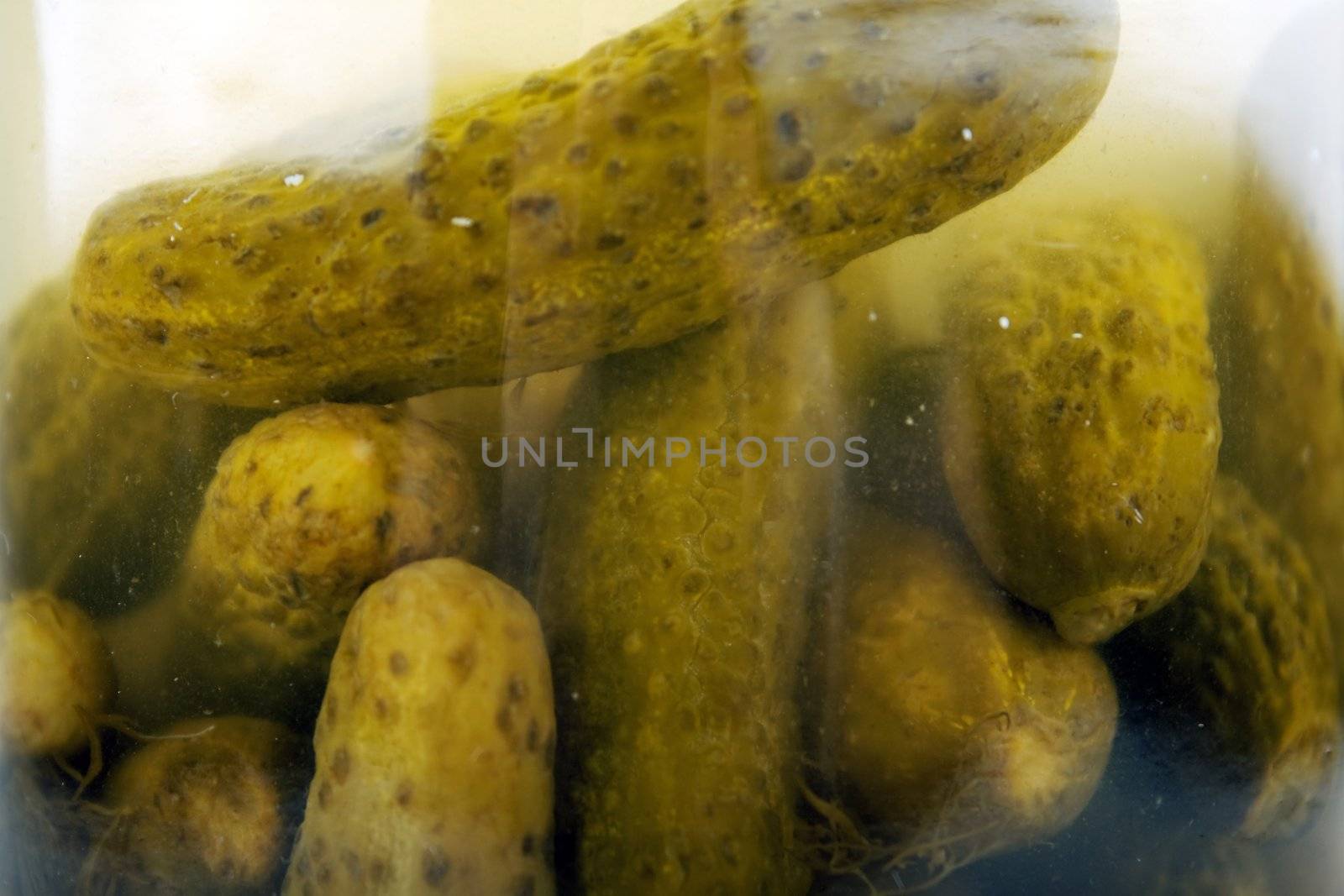 Green pickled cucumber vegetable food in glass jar