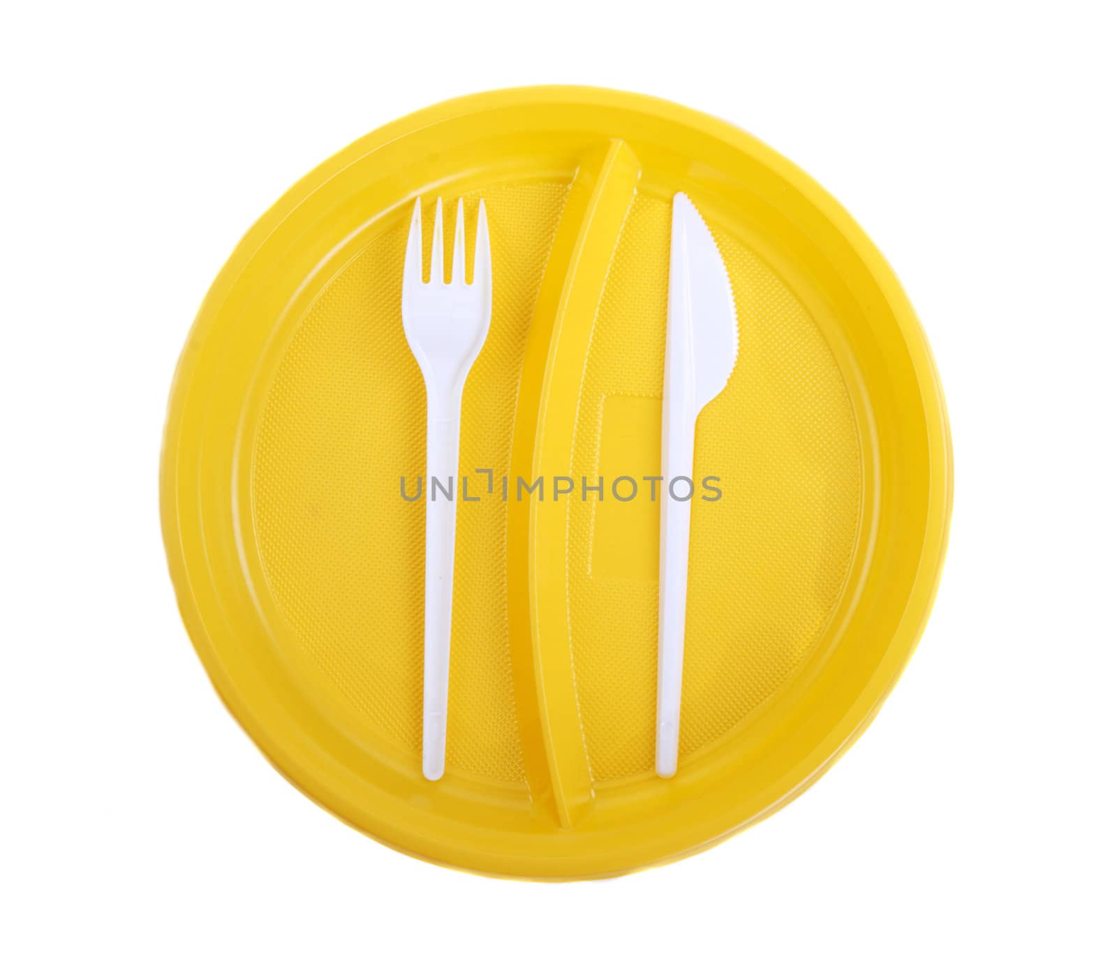 Yellow plastic plate, fork and knife on white background