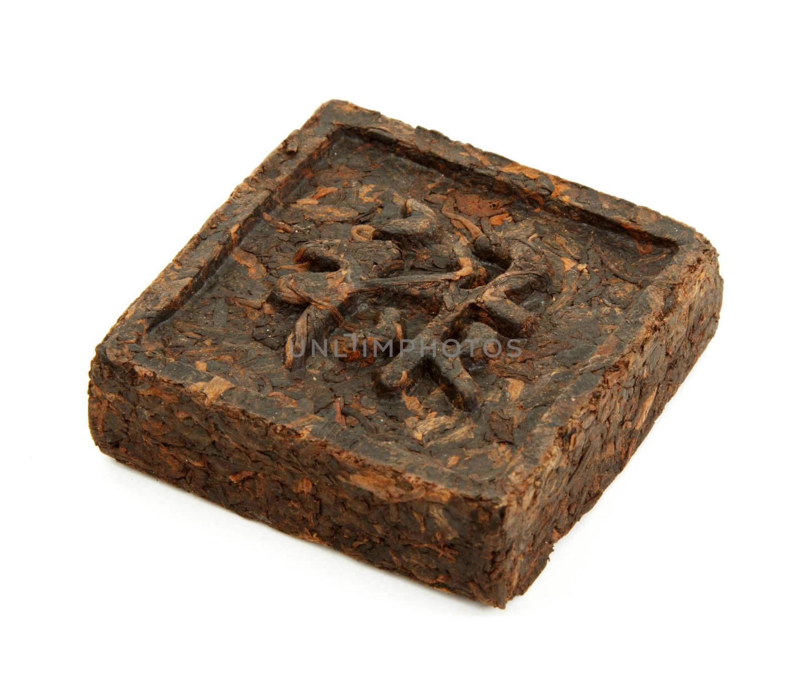 Pressed briquette of green tea with hieroglyphic on white background