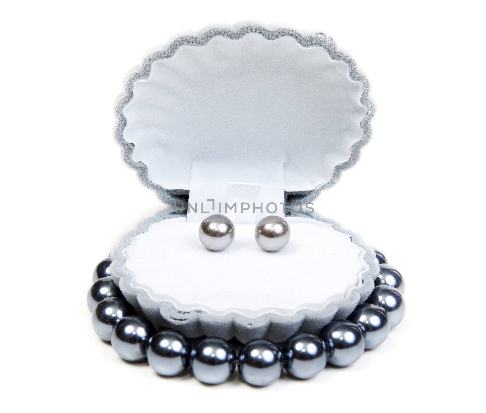 Earrings in small box and necklace on white background