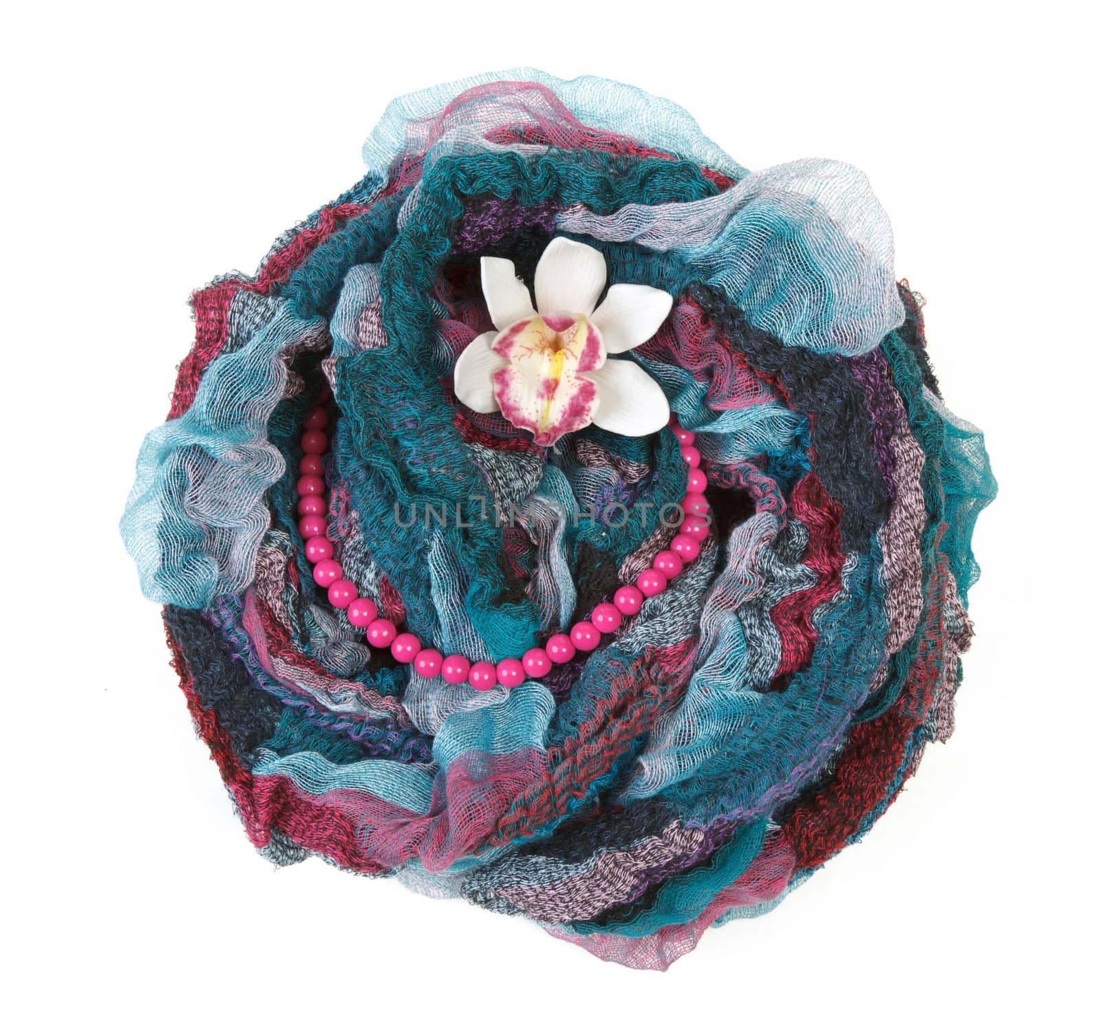 Varicoloured scarf is put with necklace around and flower on white background