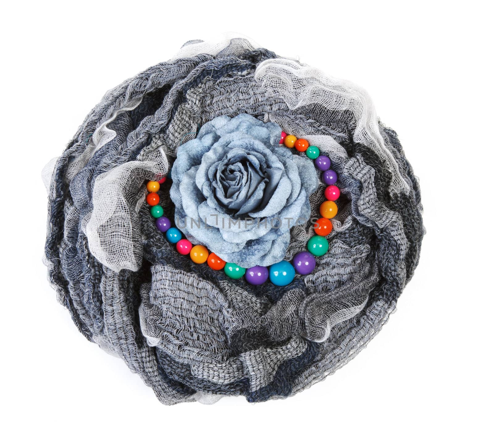 Varicoloured scarf is put with necklace around and flower on white background