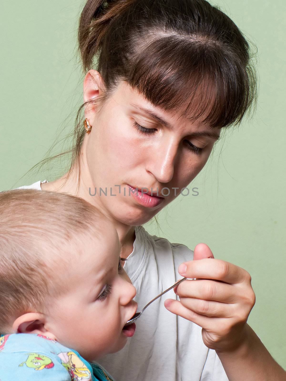 Mother and little child eating food in family care