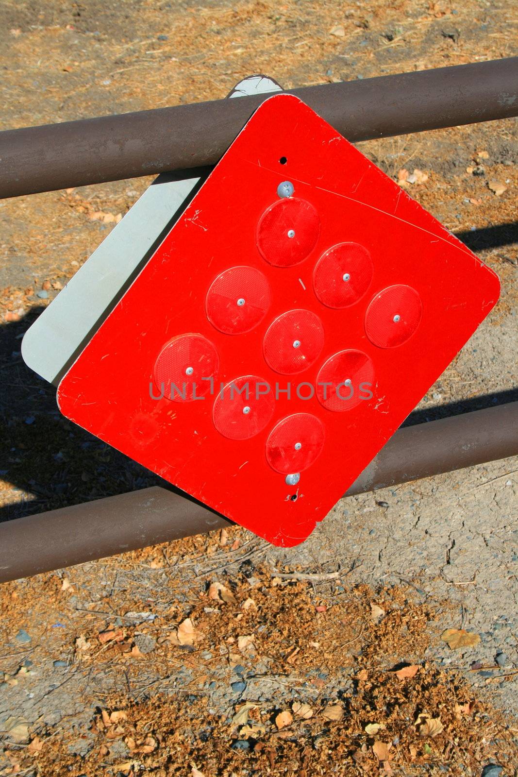 Bright red reflectors on a caution sign.
