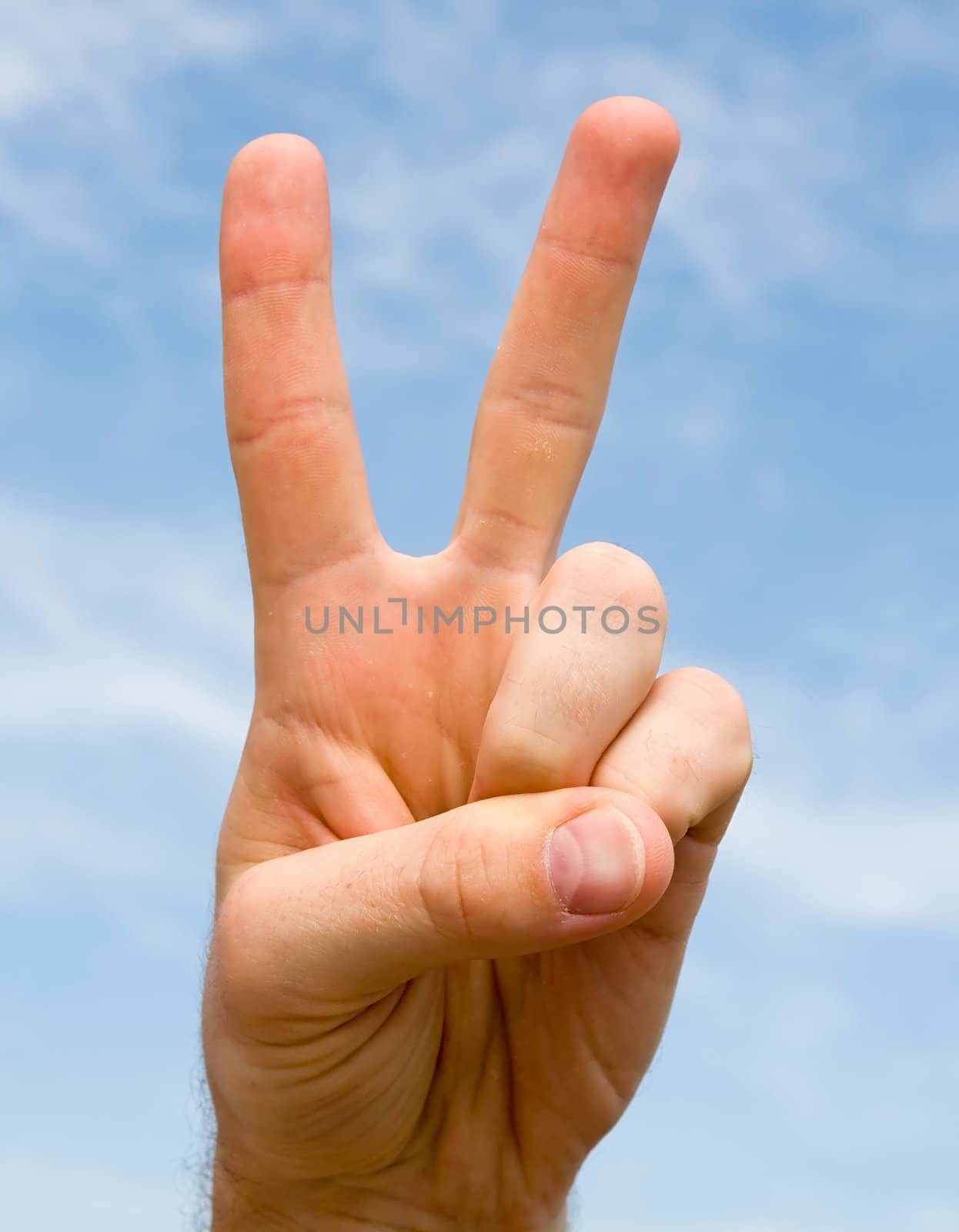 Victory sign with blue sky behind