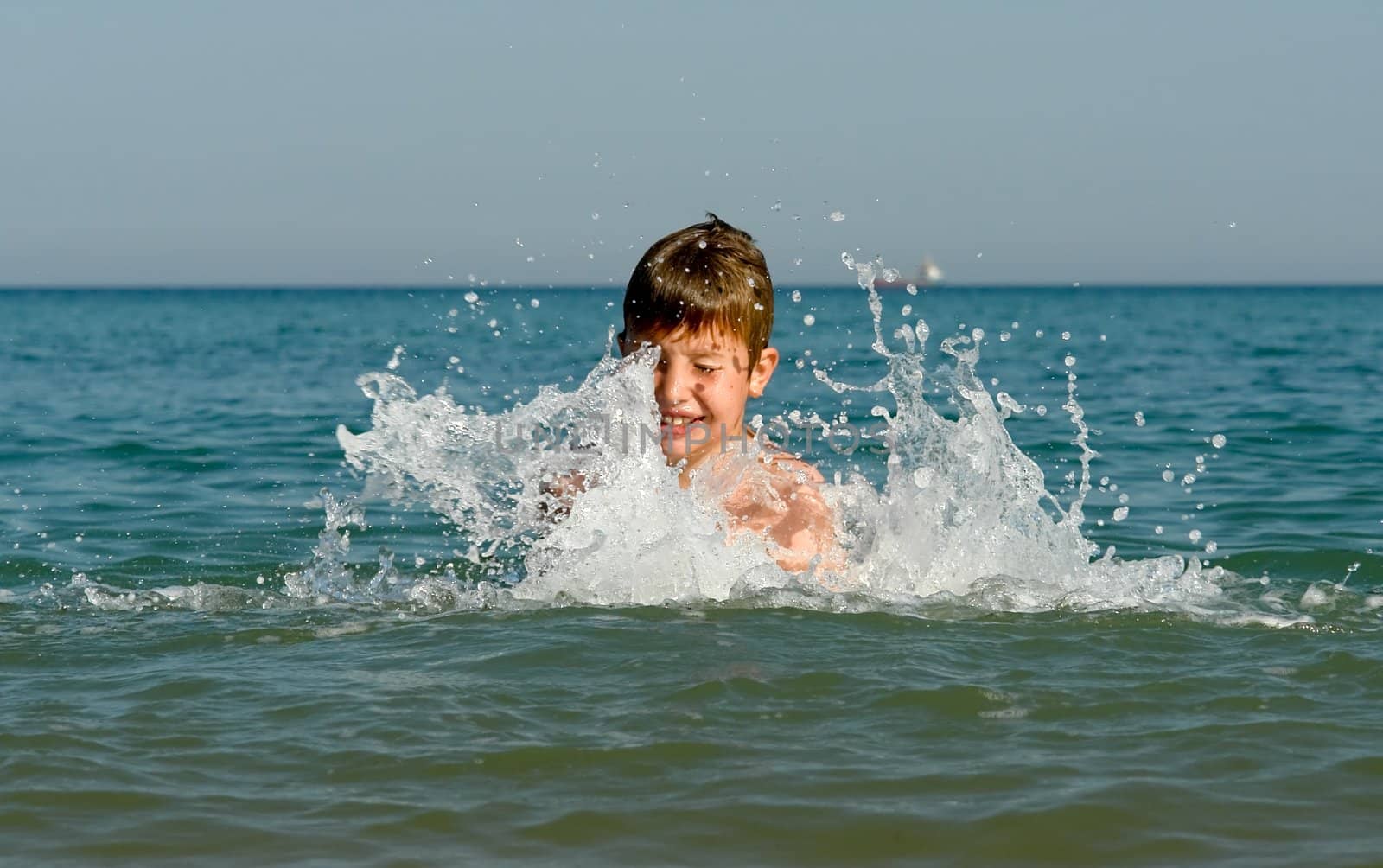 A little boy playing at the sea