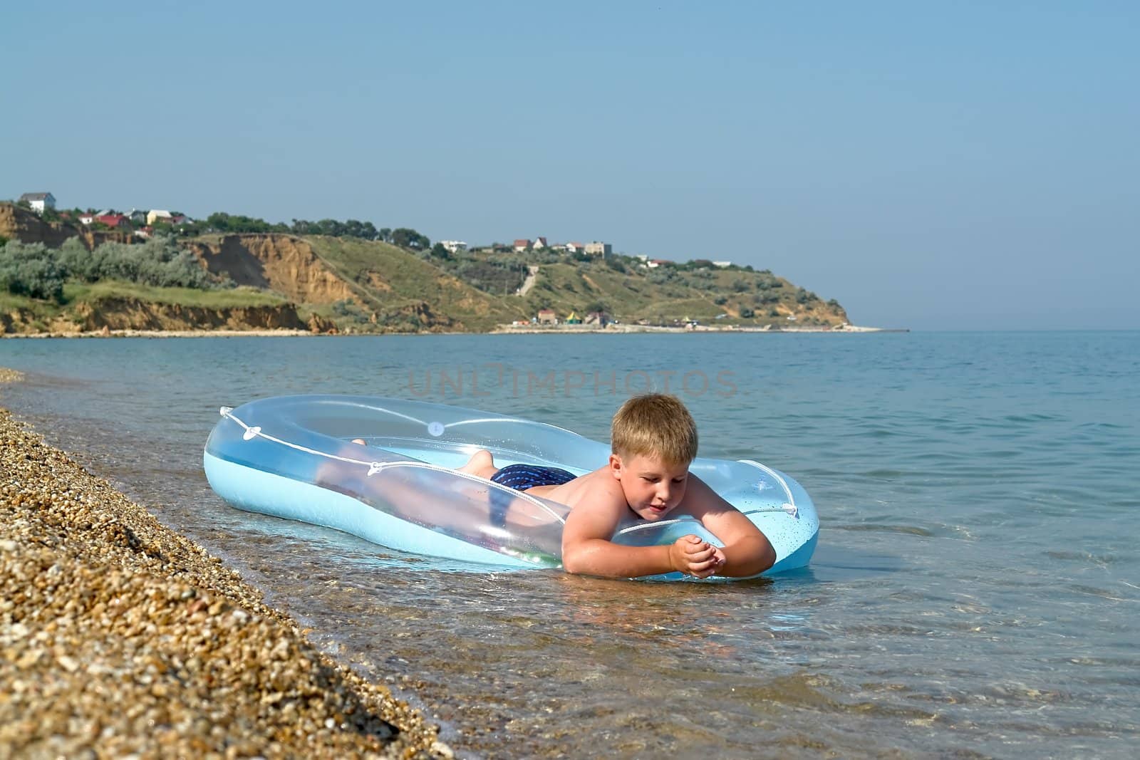 little boy in an inflatable boat on the beach