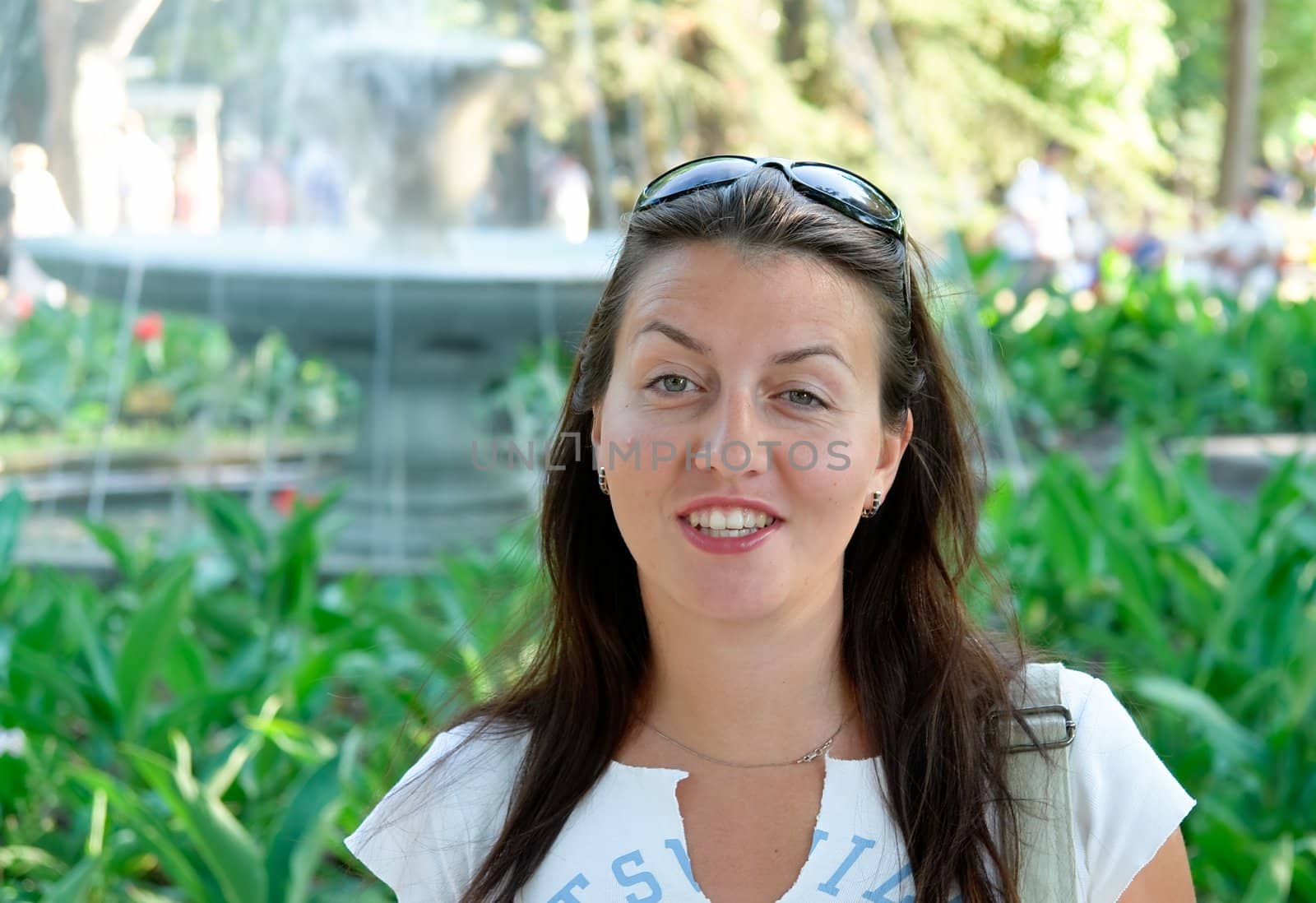 portrait of a beautiful woman with park at background