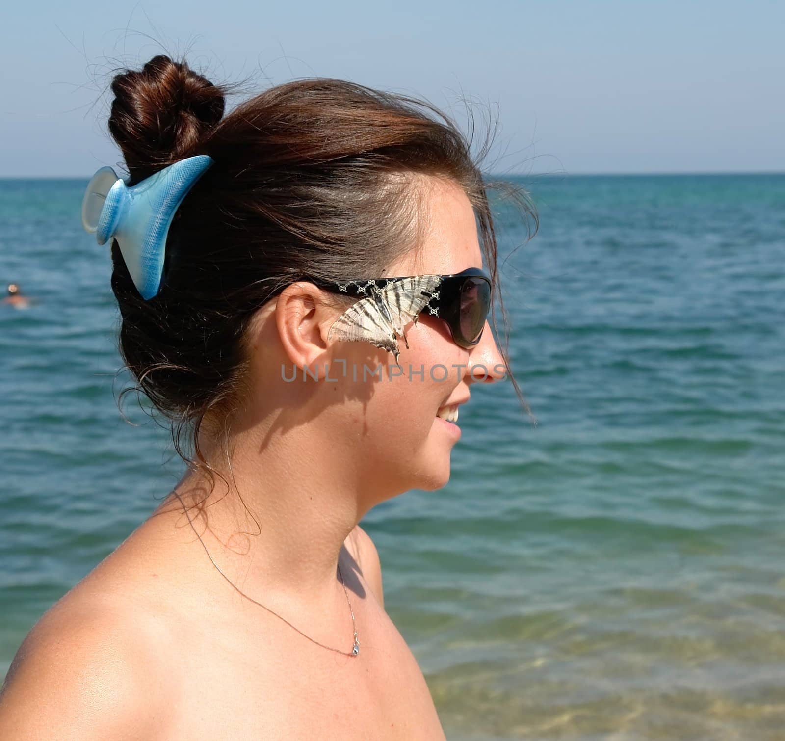 Beautiful Young Woman on the Beach.  live butterfly on the face.