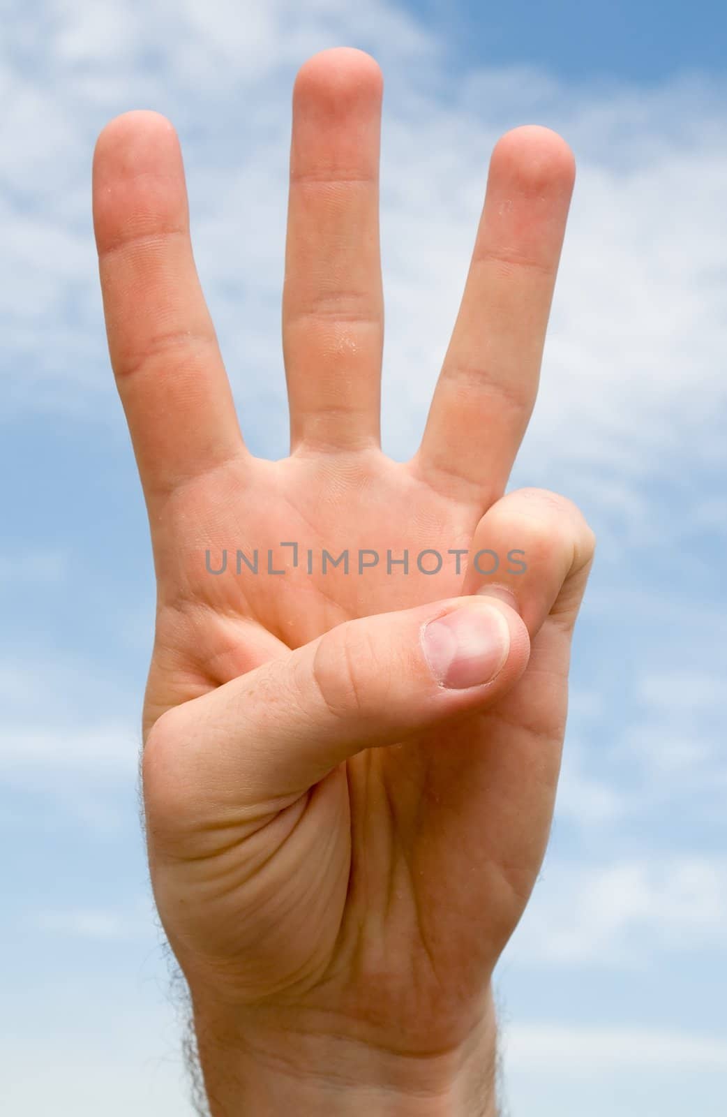 Three. Human hand on a blue sky