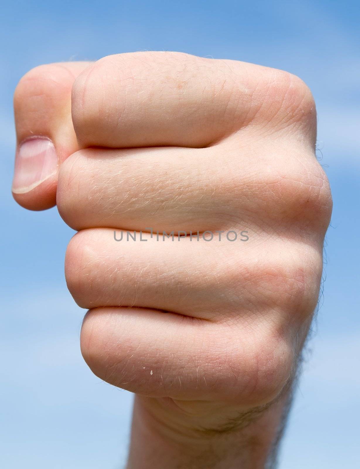 fist. Human hand on a blue sky