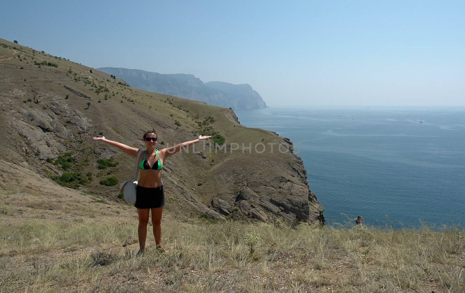 young beautiful woman against  mountains and the sea