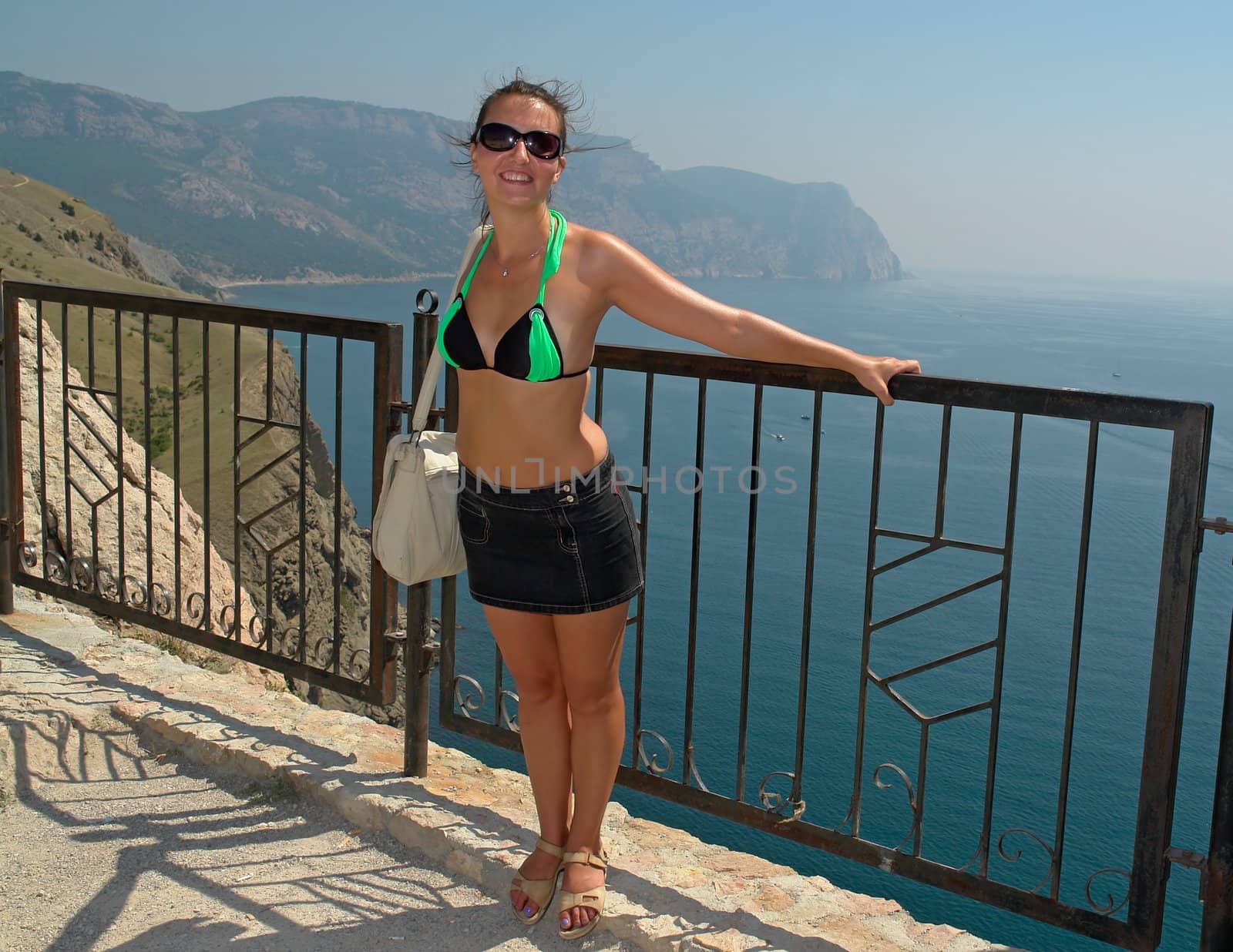 young beautiful woman against  mountains and the sea