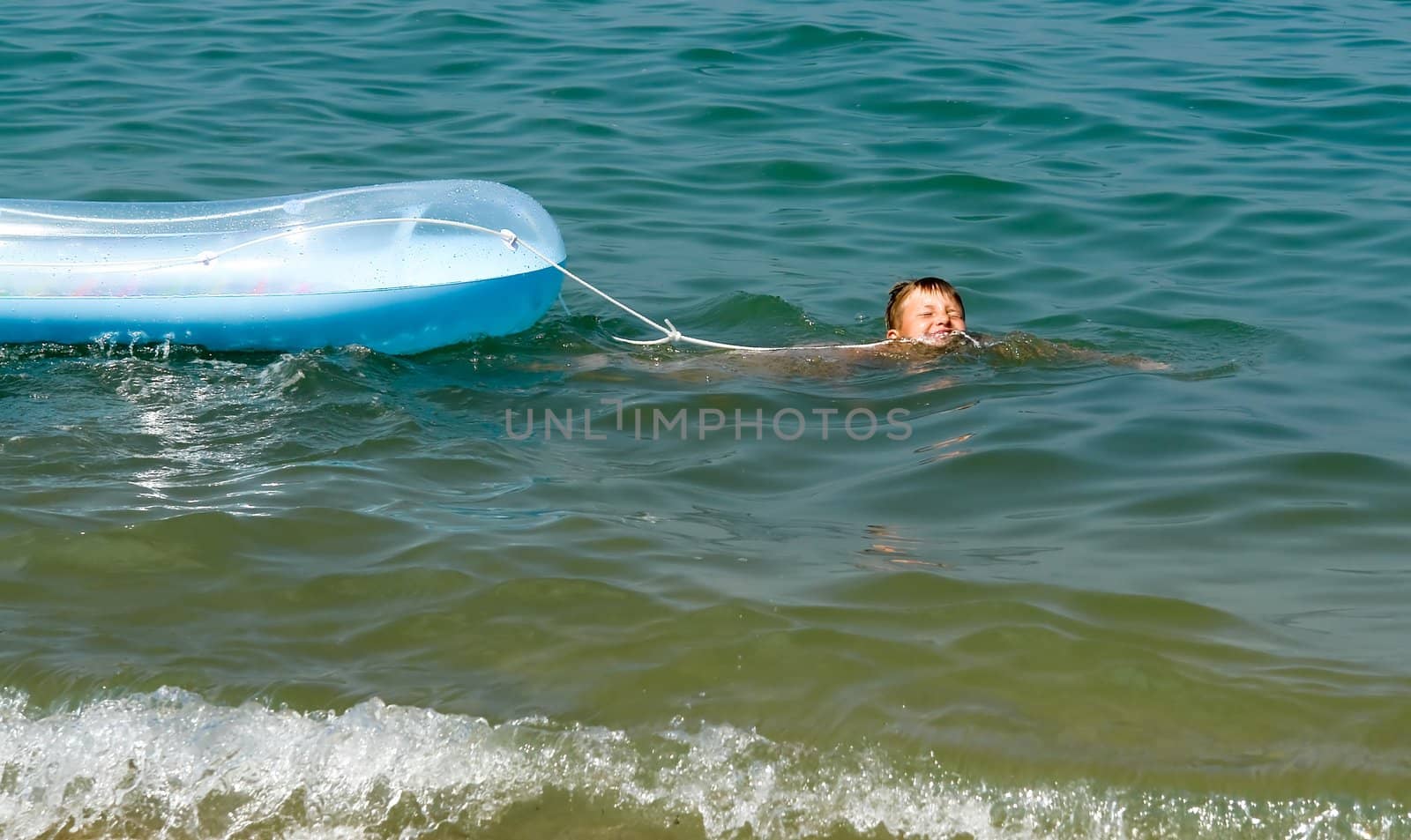 The little boy pulls an inflatable boat