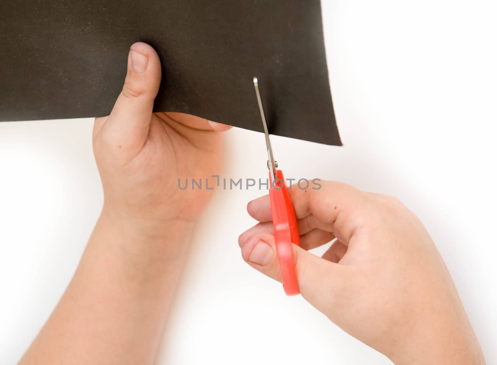 Children's hands with scissors cut a paper