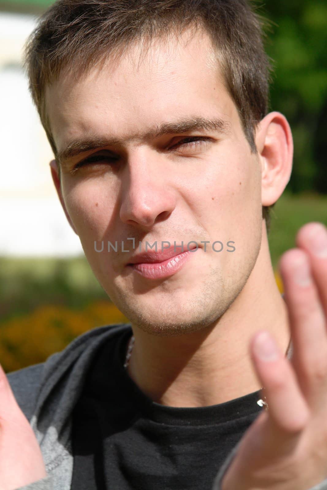 Portrait of the young man in a sharp sunlight