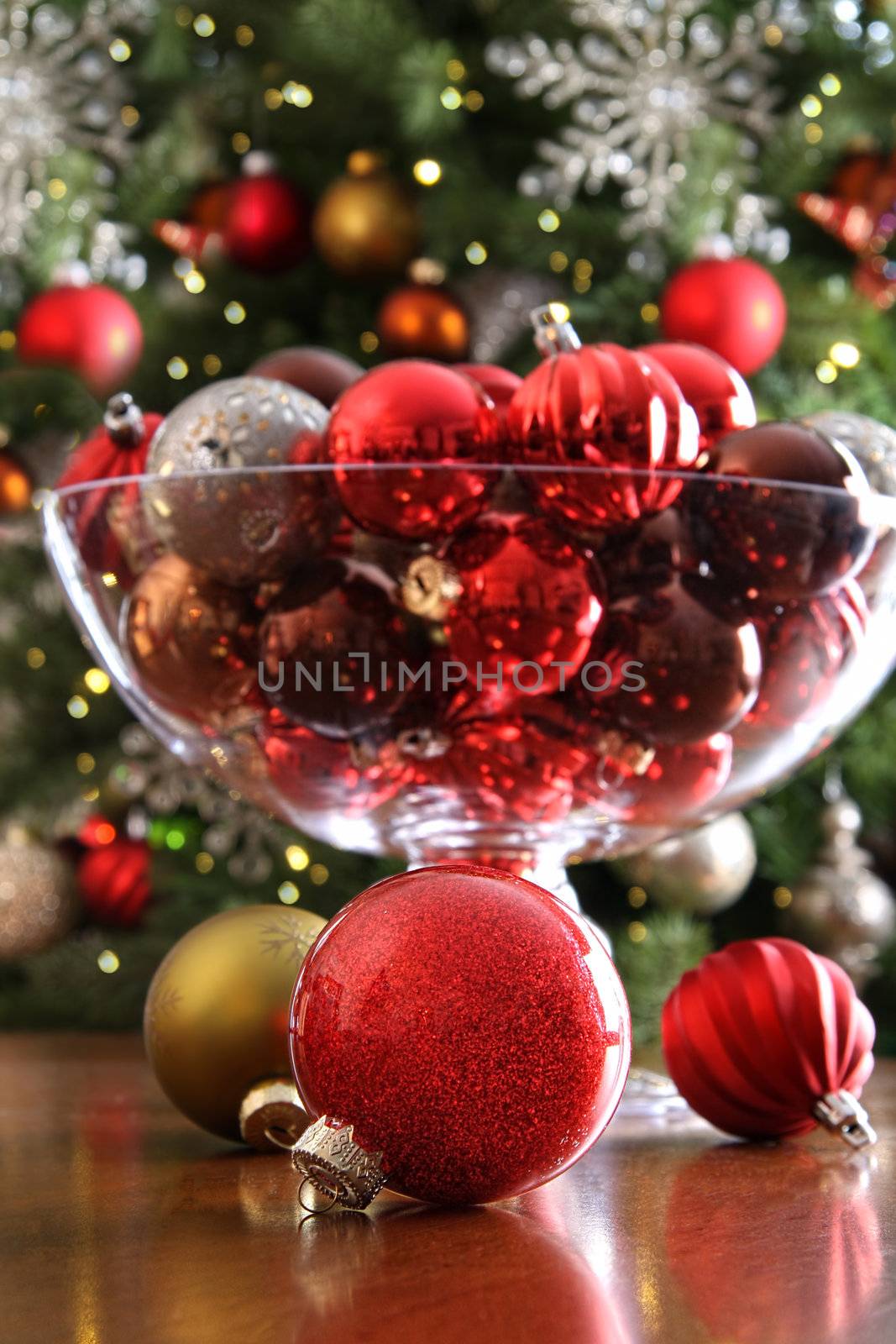 Christmas ornaments on table in front of holiday tree