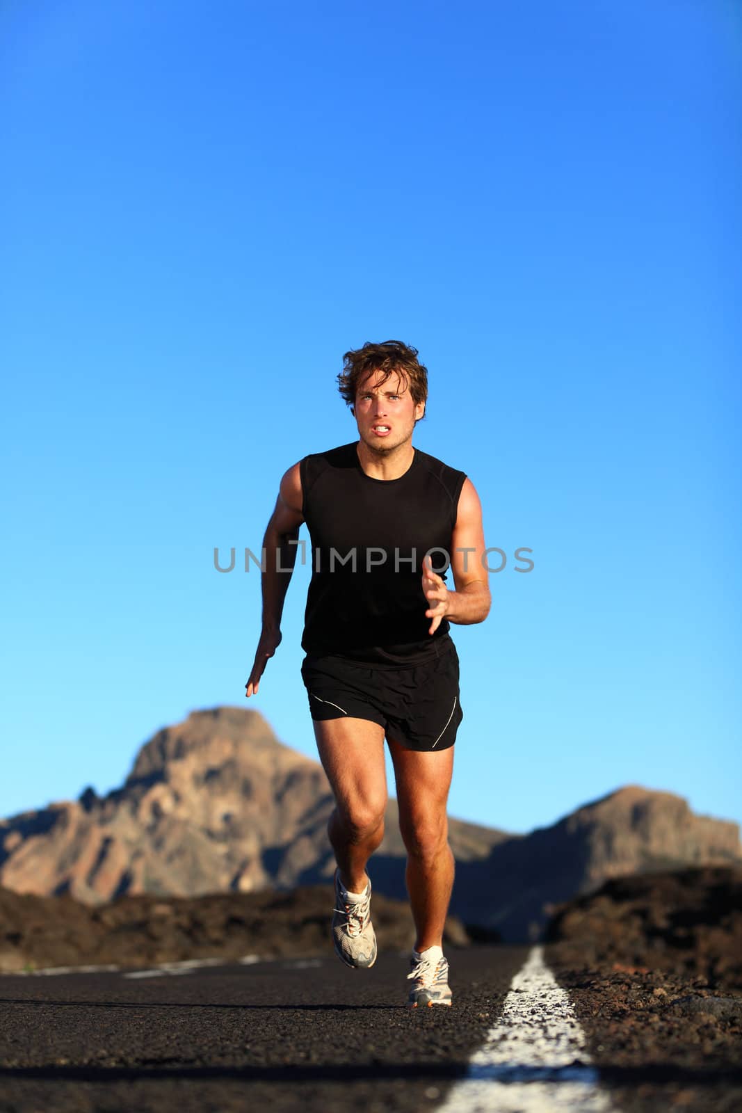 Running - male runner. Man sprinting during outdoor workout training session. Male caucasian athlete running on road in nature.