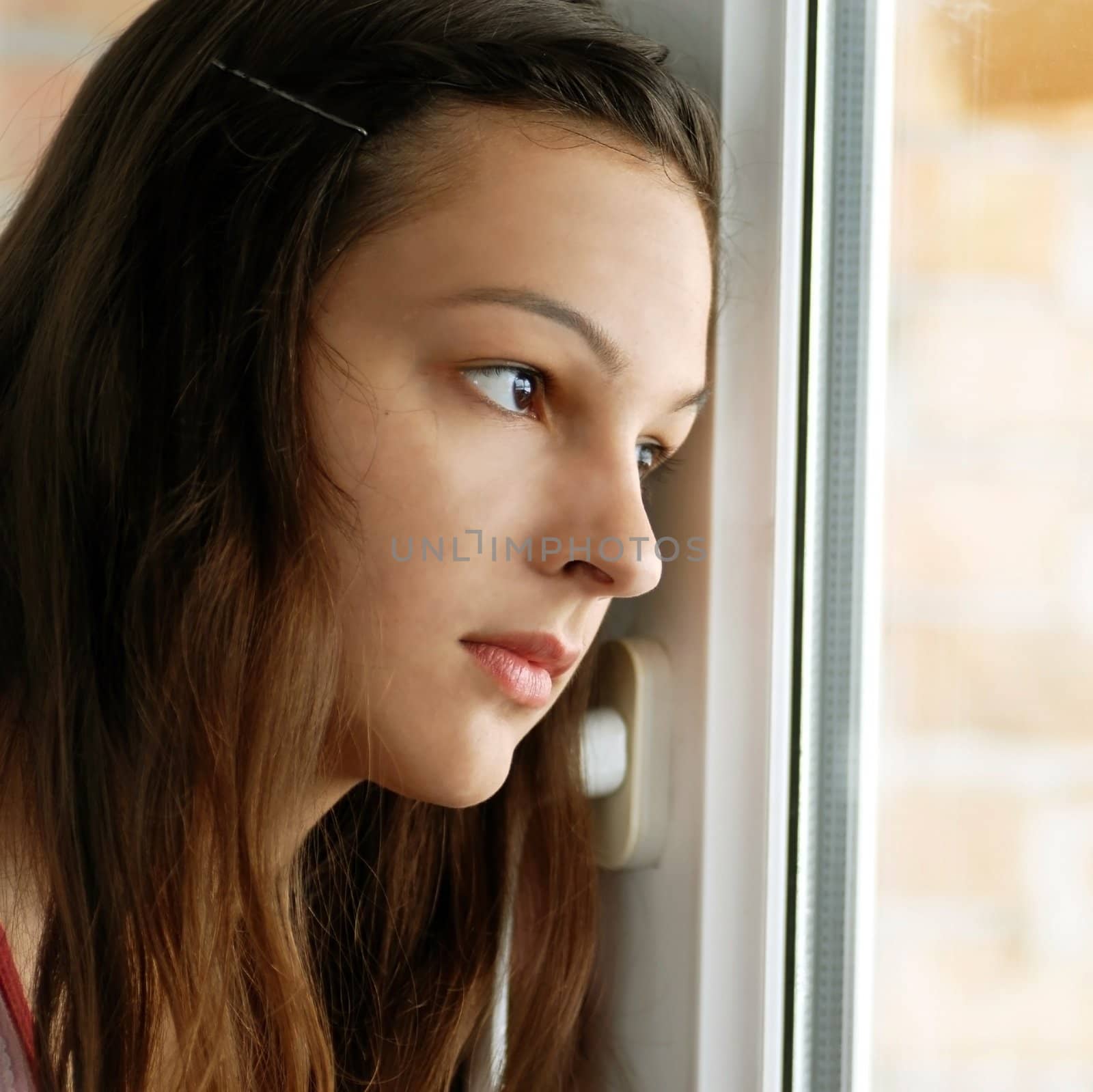 Teenage girl looking out  window by simply