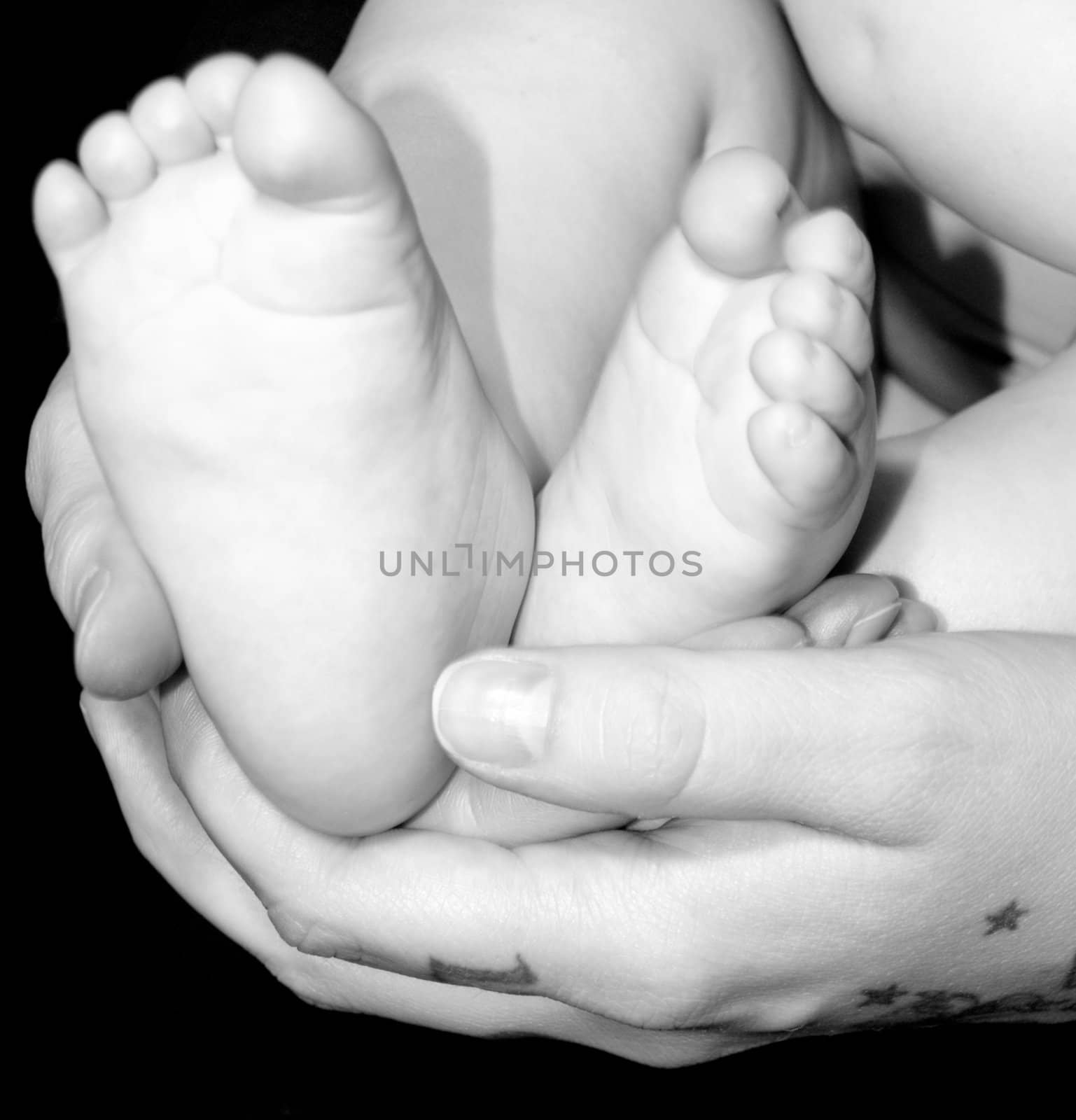 A very cute little infant feet in a mother's hands