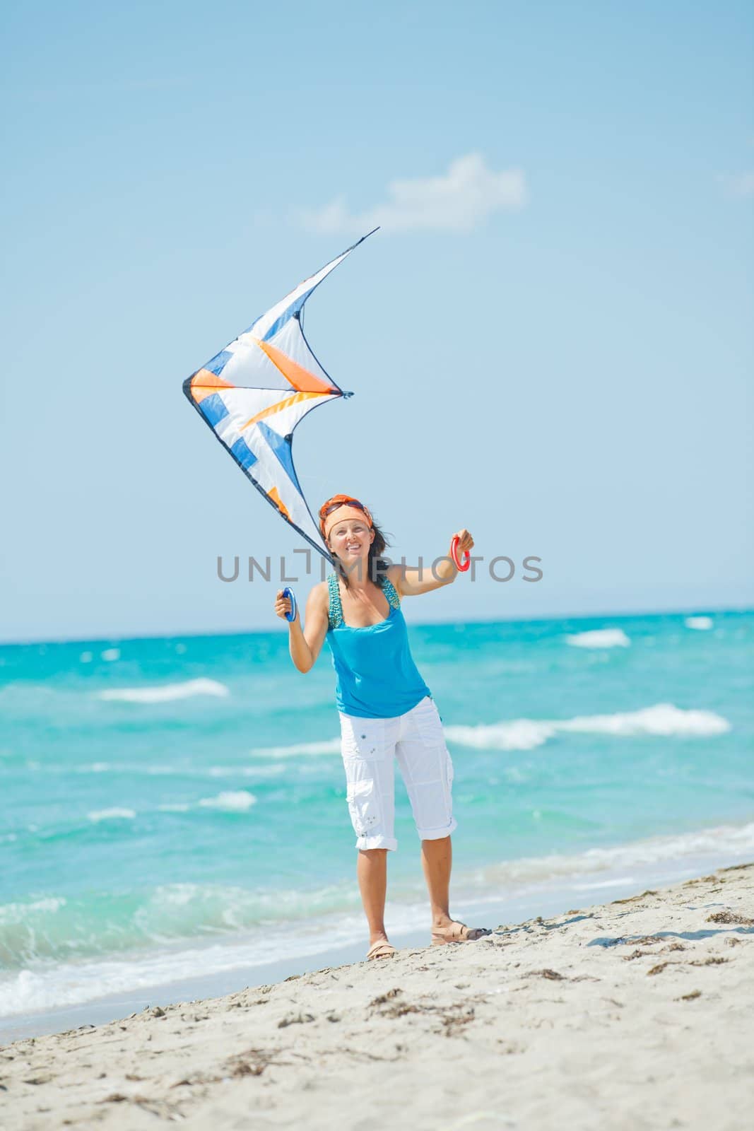 Young cute woman playing with a colorful kite on the tropical beach. Vertikal veiw