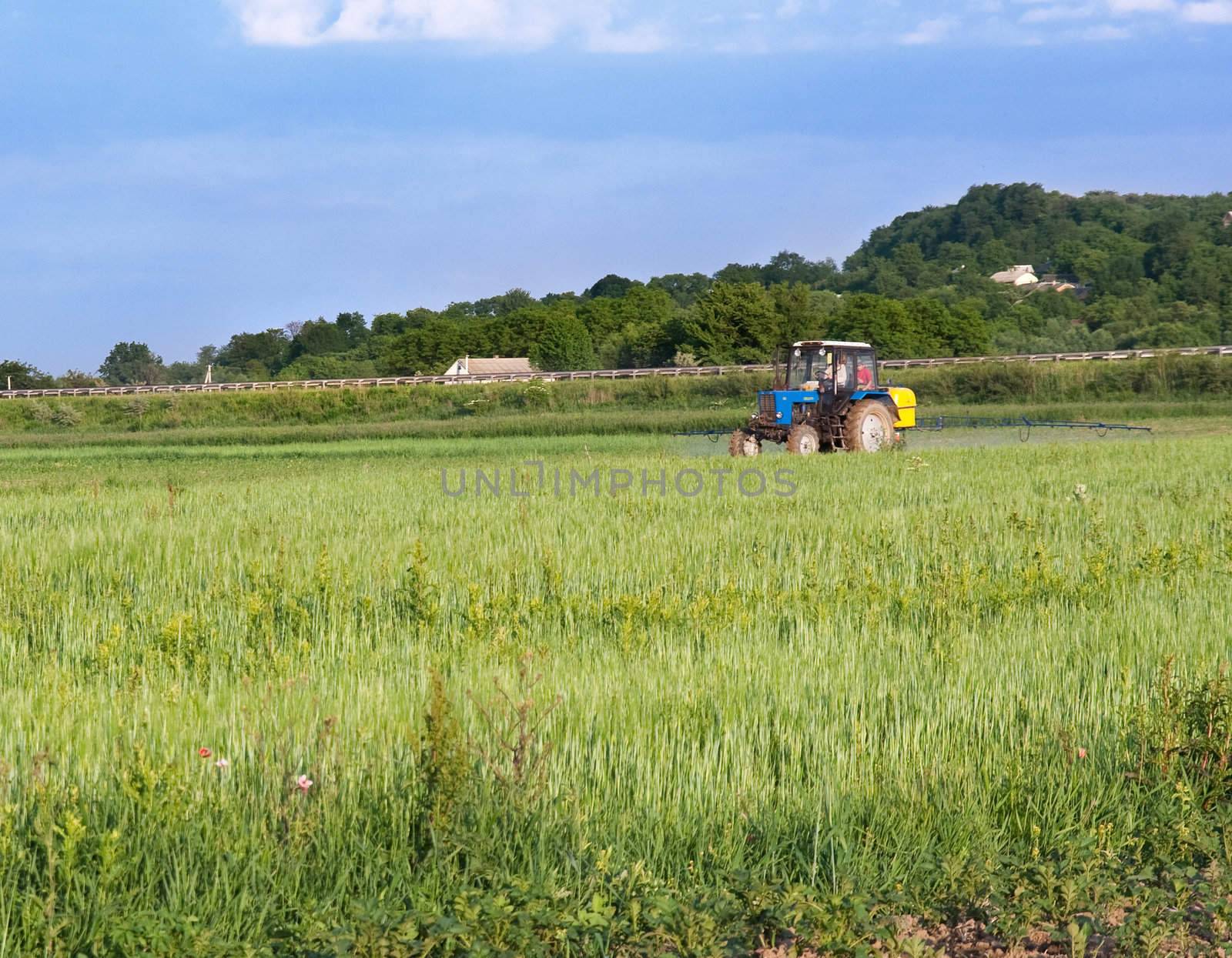 The tractor processes chemicals a field