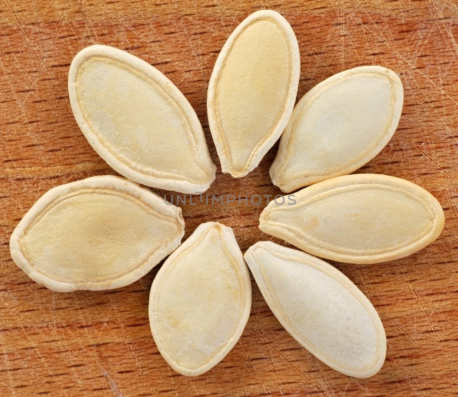 closeup of pumpkin seeds on wooden brown background