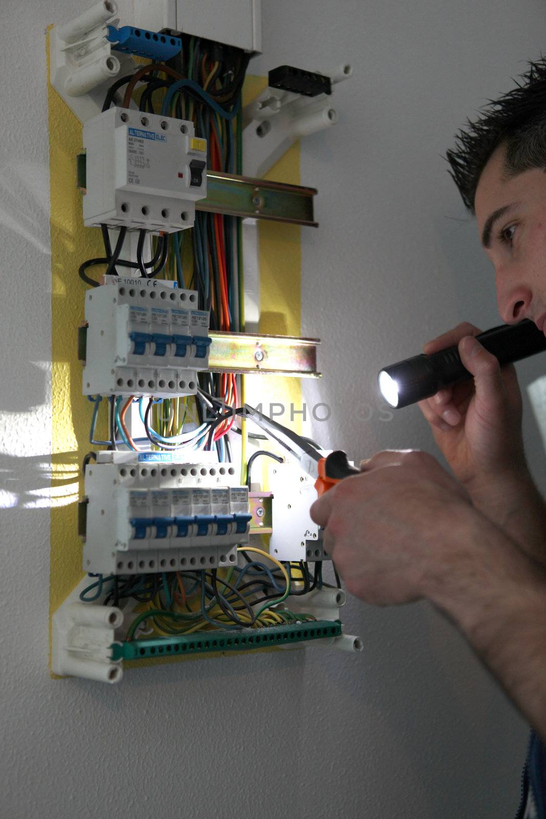 Tradesman fixing a circuit breaker by phovoir