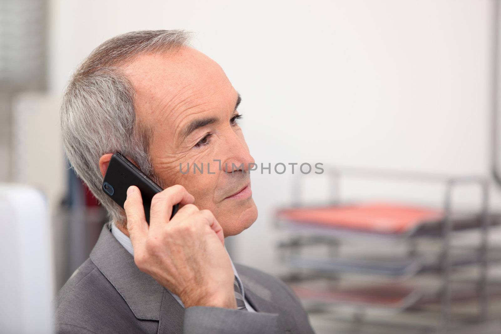Senior man receiving call by phovoir