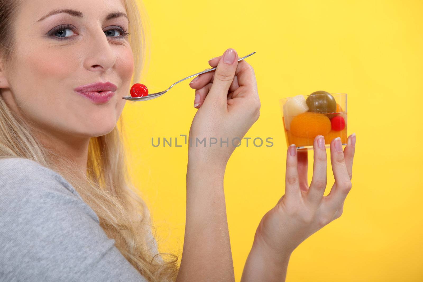 Blond woman eating fruit cocktail